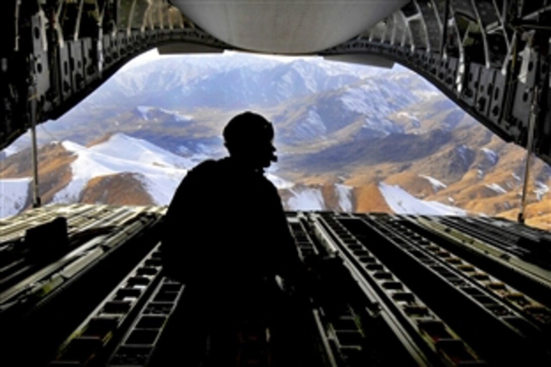 U.S. Air Force Tech. Sgt. Kevin Owen sits on the ramp of a C-17 Globemaster III aircraft while flying over the mountains of Afghanistan after an airdrop mission, Feb. 2, 2010. Owen is a loadmaster assigned to the 816th Expeditionary Airlift Squadron. The aircraft's crew dropped 34 container bundles to an undisclosed base in Afghanistan as part of a combat resupply mission.