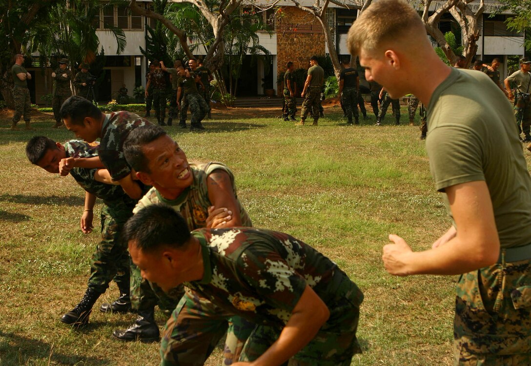 Cpl. Jeremy Hurlbert, a military policeman with Combat Logistics Battalion 31 (CLB-31), 31st Marine Expeditionary Unit (MEU), instructs a Royal Thai Marine on how to properly apply a non-lethal takedown move during a subject-matter expert exchange (SMEE) between Royal Thai security Marines and CLB-31, Feb. 5.  The MEU is currently participating in exercise Cobra Gold 2010 (CG’ 10). The exercise is the latest in a continuing series of exercises design to promote regional peace and security.