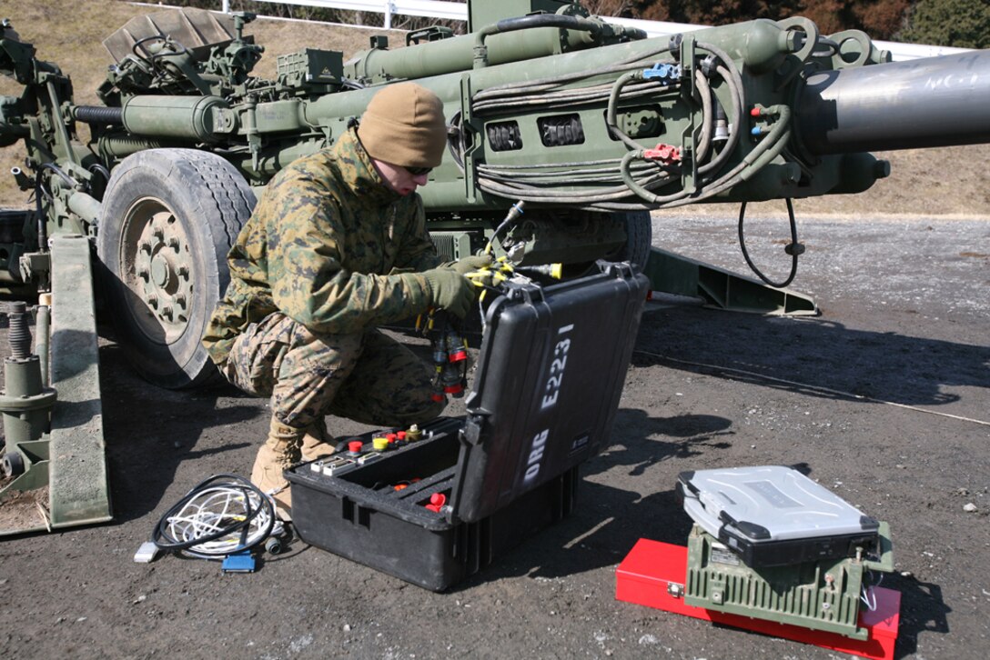 Pfc. Ryan A. Cole, a towed artillery weapons technician with Armament Repair Platoon, Ordnance Maintenance Company, Combat Logistics Regiment 35, 3rd Marine Logistic Group, III Marine Expeditionary Force, organizes cables from his diagnostics kit that are used to connect the M777 howitzer to a laptop containing the Interactive Electrical Technical Manual diagnostic software during the Hijudai Artillery Relocation Training Program Exercise Feb. 5. The regularly-scheduled artillery training enables Marines to maintain their operational readiness to respond to any contingency where artillery, crew served weapons and small arms fire would be required.