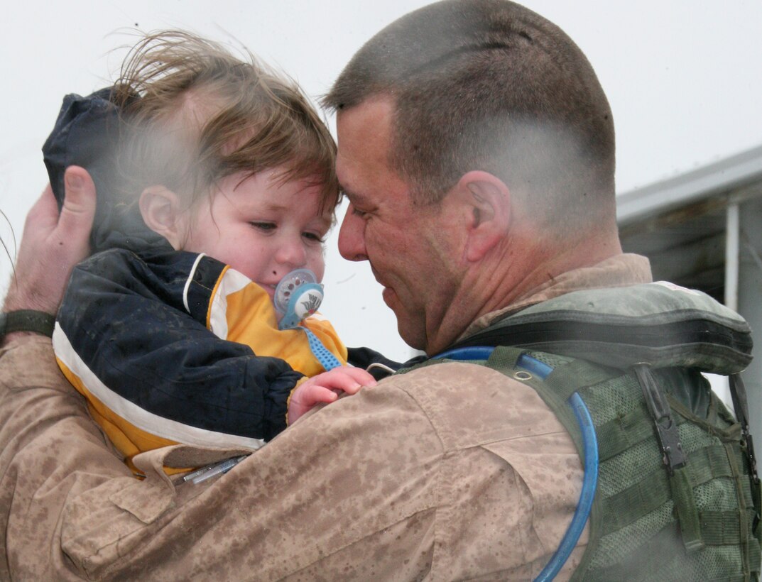 Lt. Col. George Lambert, an electronic countermeasures officer with Marine Tactical Warfare Squadron 3, holds his son on the Cherry Point flight line after returning from a 7-month deployment to Al Asad Air Base, Iraq. VMAQ-3’s Prowlers were the last Marine aircraft to leave Iraq in support of Operation Iraqi Freedom.