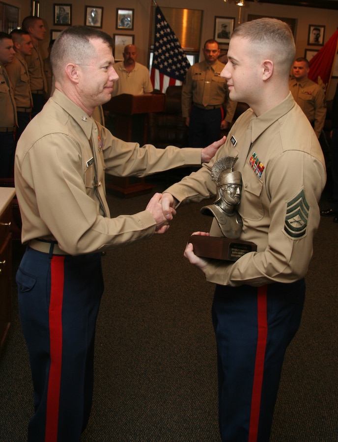 GySgt. Joshua Shaffer, SNCOIC or RSS Kokomo, is presented with the Centurion trophy after having the title bestowed upon him.  Shaffer enlisted 100 qualified young men and women, 80 percent in the upper mental groups and all them were Tier 1, High School Graduates.