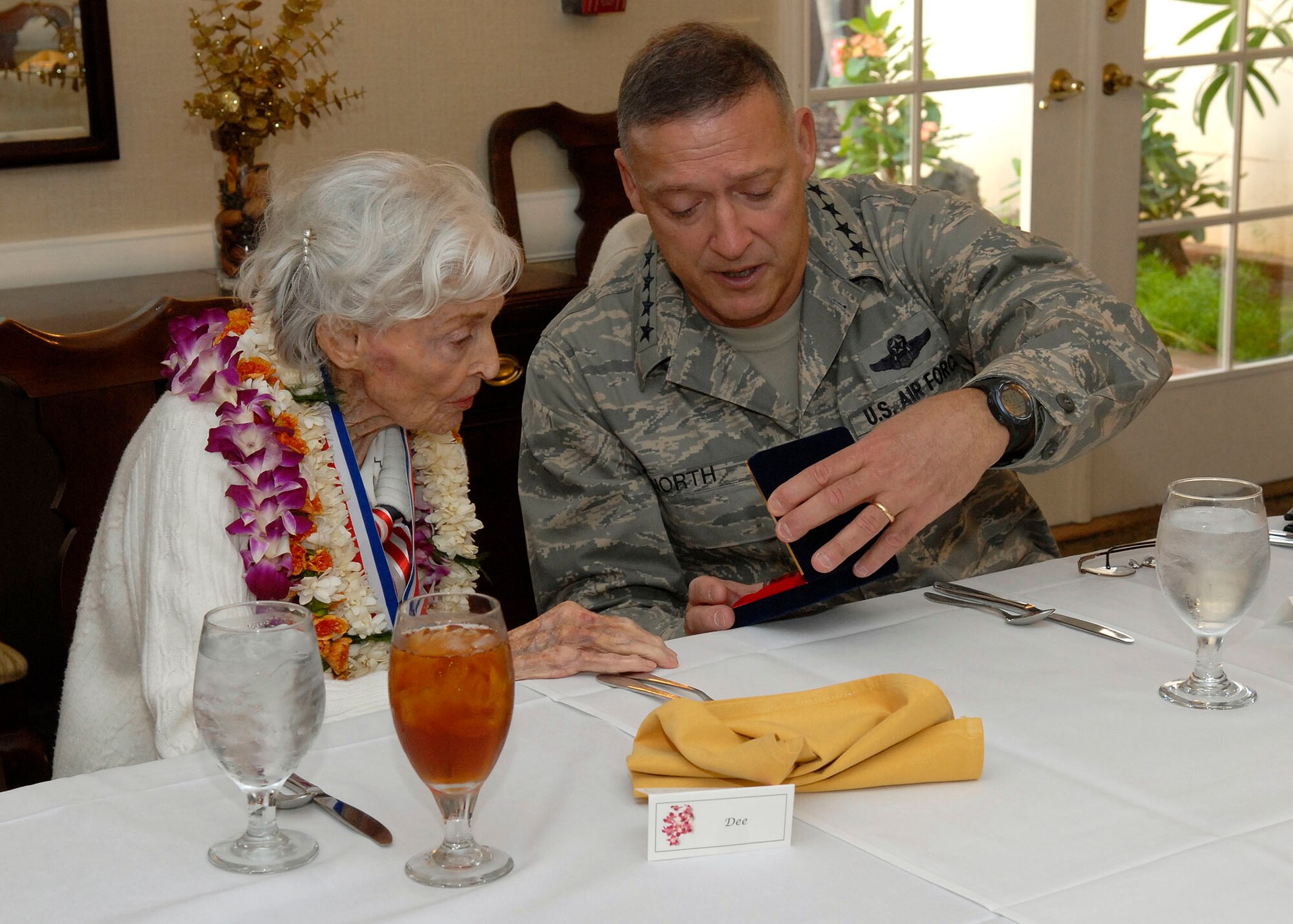 Gen. Gary North Pacific Air Forces commander, presents a gift to, Mrs. Doris Avery (Dee), at a luncheon in her honor at the Officers Club, Joint Base Pearl Harbor Hickam, Hawaii, Feb. 5, 2010. (U.S. Air Force photo/Tech. Sgt Jerome S. Tayborn)