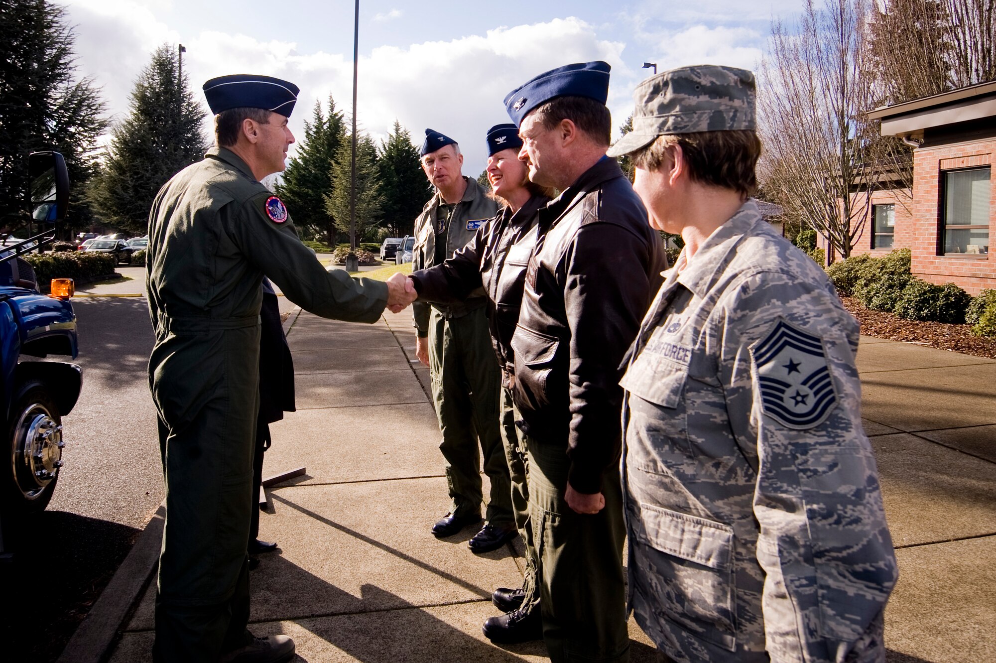 Gen. Raymond Johns, Jr., Air Mobility Command commander, right, shakes hands Jan. 23,  with Col. Lisa Tank, 446th Airlift Wing vice commander, as Col. William Flanigan, far left, looks on.  Also standing by to greet the general are Col. David Pavey, 446th Operations Group commander, and Chief Master Sgt. Gloria Bennett, 446th AW command chief. While visiting McChord Air Force Base, Wash.,  General Johns met with 446th AW Reserve Airmen and civilians. (U.S. Air Force photo/Abner Guzman)