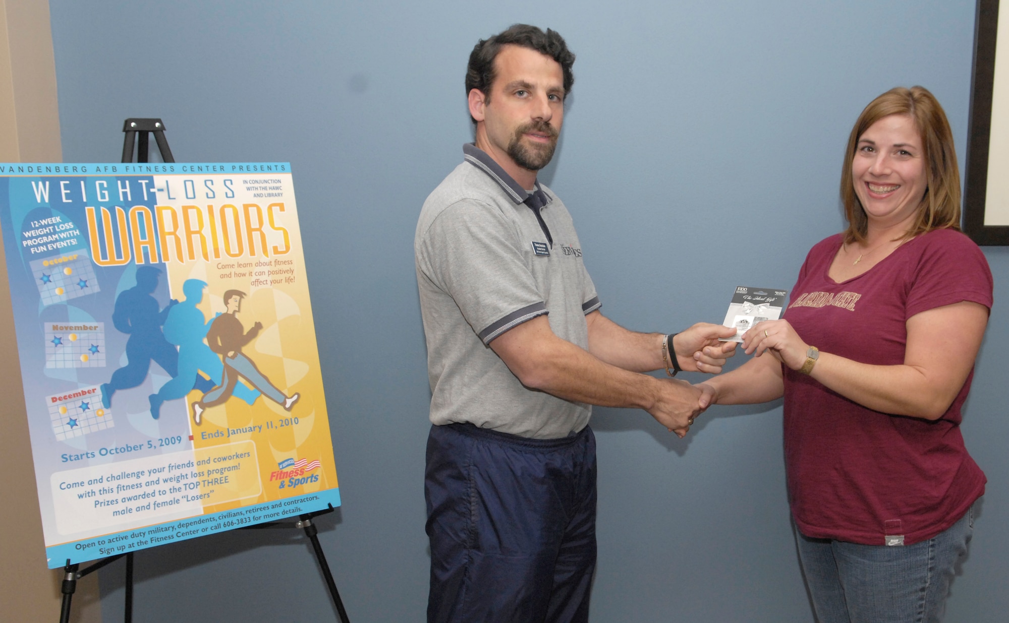 VANDENBERG AIR FORCE BASE, Calif. --  With joy, Autumn Marshal, right, accepts a $100 gift card from Thomas Anastasio, the base fitness center assistant director. Ms. Marshal won the gift card by placing first in Weight-Loss Warrior program in the women's category.  (U.S. Air Force photo/Airman 1st Class Andrew Lee) 
 