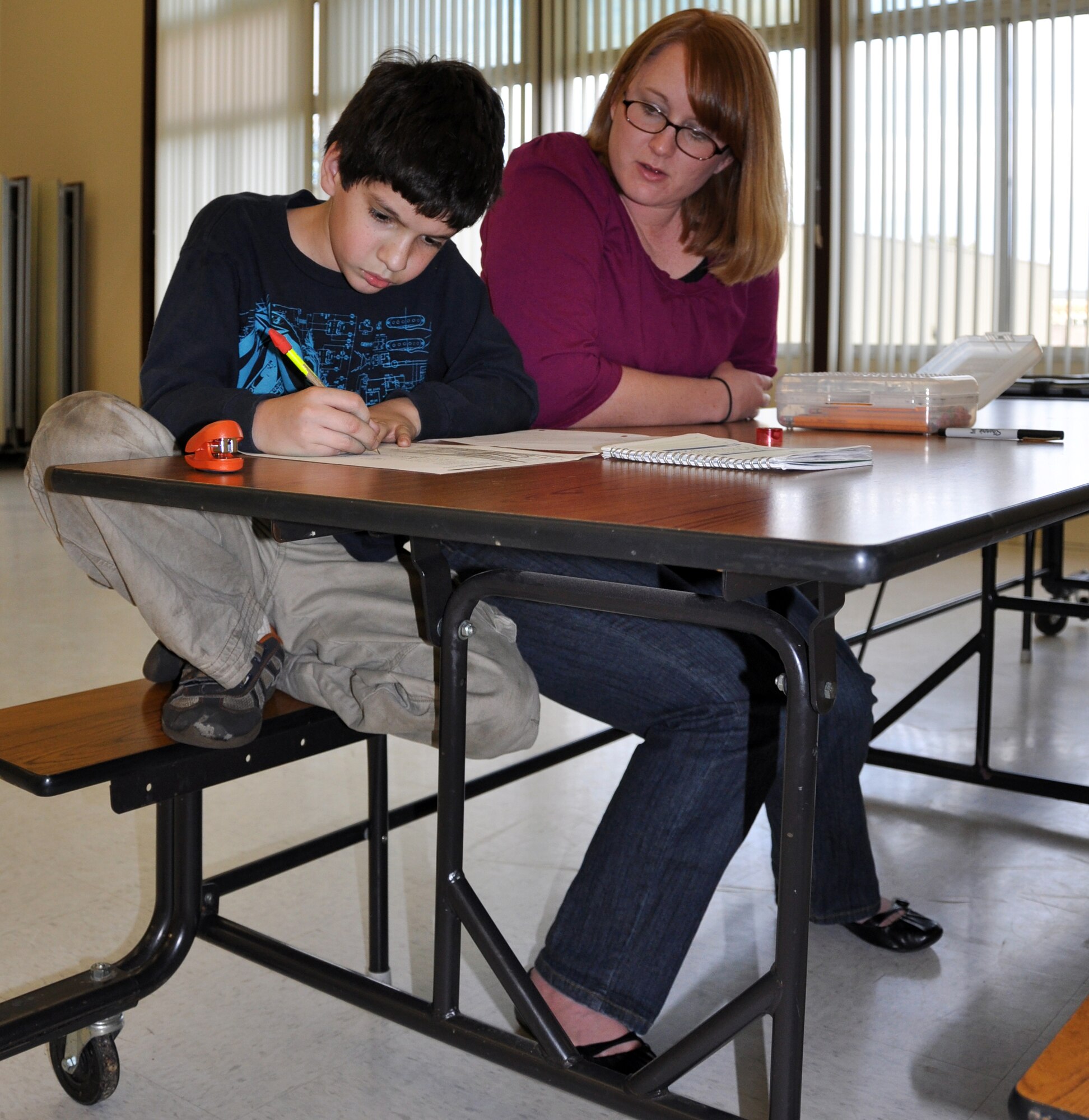 Krisha Padgett,a children's facilitator, helps Joseph Blume, a student, do his homework Tuesday as part of the Operation Hero program at Scandia Elementary School. (U.S. Air Force photo/Airman Michael Battles)
