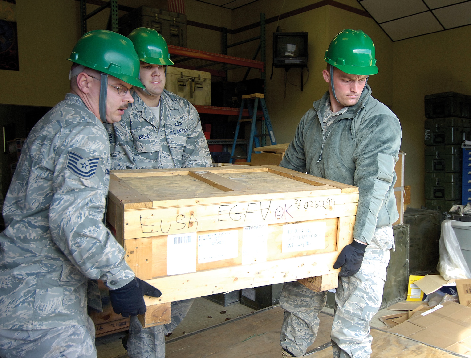 Working as a smooth team, 32nd Combat Communications Squadron Airmen palletize equipment they’ll need for relief efforts in Haiti. From left are, Tech. Sgt. Robert Longnecker, Staff Sgt. Justin Usera and Senior Airman Benjamin Black. (Air Force photo by Margo Wright)
