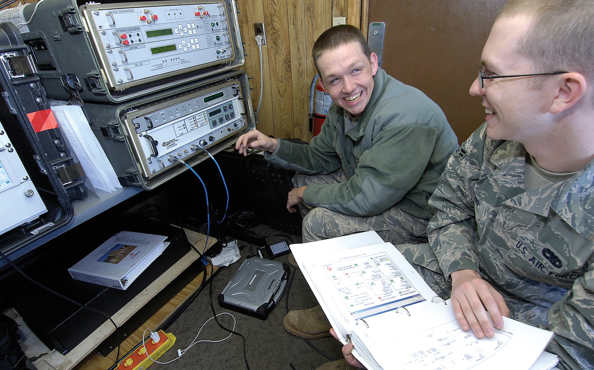 Exercises, war and areas hit by disaster need communications and members of the 3rd Combat Communications Group meet those challenges as a way of life. Airmen 1st Class Daniel Swann, left, and Zachary Taylor enjoy a quick joke while they test satellite communications equipment before it’s packed for an exercise at Minot, N.D. (Air Force photo by Margo Wright)