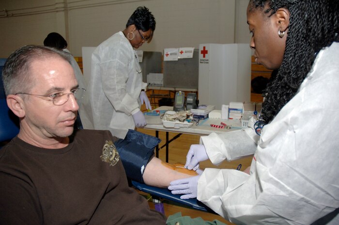 David Shuff remains calm as Tish Prioleau assists him in donating blood during the Joint Base Charleston blood drive held at the Fitness and Sports Center Feb. 3. The need for blood is always great and the American Red Cross is constantly looking for individuals willing to donate. Mr. Shuff is a retired Air Force master sergeant working with the 437th Maintenance Squadron Aerospace Ground Equipment Flight as the day shift maintenance supervisor and is married to Master Sgt. Cynthia Shuff who currently serves on active duty with the 628th Logistics Readiness Squadron as superintendent for the installation deployment readiness cell. Ms. Prioleau is a collections specialist with the American Red Cross Charleston Service Center. (U.S. Air Force photo/Staff Sgt. Marie Brown)