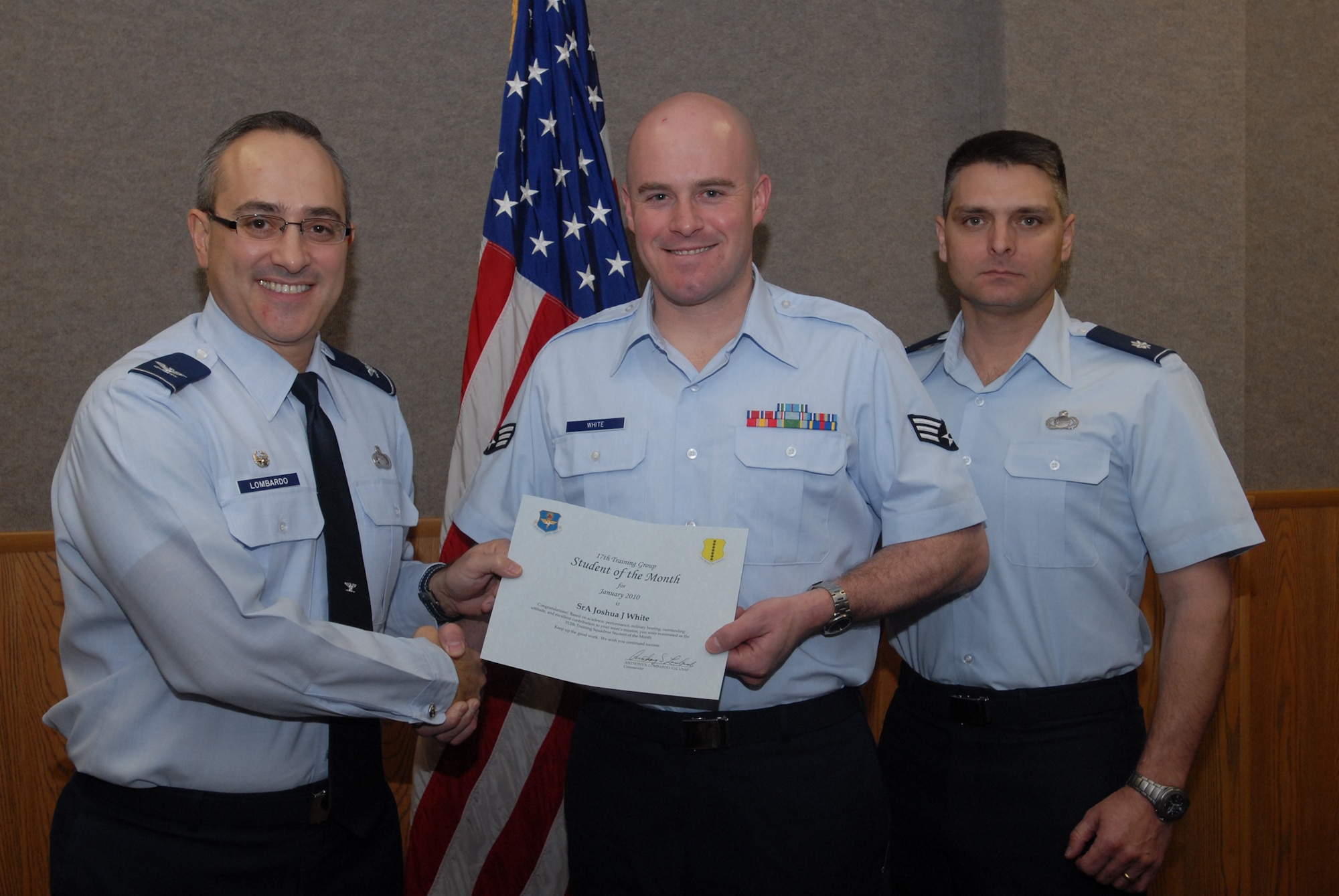 Col. Anthony Lombardo, 17th Training Group commander presents a Student of the Month certificate to Senior Airman Joshua White, 312th Training Squadron student, Feb. 2, as  Lt. Col. Erick Lawson, 316th Training Squadron commander looks on. Every month, Goodfellow's training squadrons choose their top enlisted student, both in academic performance and in ability to meet military training standards, for recognition as Student of the Month. (U.S. Air Force photo/ Senior Airman Tong Duong)