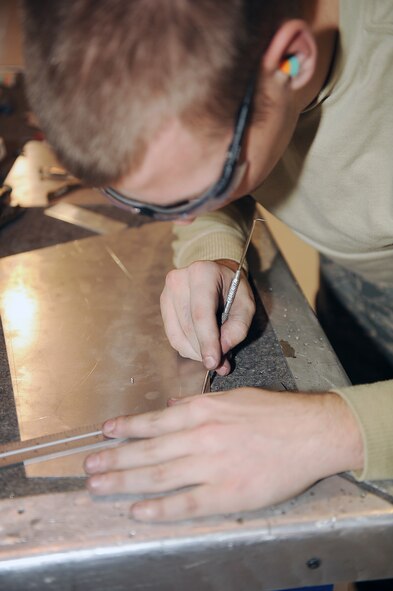 Airman 1st Class Mark Cote, 4th Equipment Maintenance Squadron aircraft structural maintenance apprentice, lays out cut lines for a simulated aircraft structure during on-the-job training at Seymour Johnson Air Force Base, N.C., Feb. 3, 2010. The cut lines are laid out on the SAS so that the part can be trimmed down to fit the correct dimensions for the aircraft. Cote hails from Fuquay Varina, N.C. (U.S. Air Force photo/Senior Airman Ciara Wymbs) 