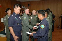 Special Group Captain (Brig Gen equivalent) Thawonwat Chantanagama, Deputy Director, Director of Operations, Royal Thai Air Force (left in blue), Lt. Col. Corey L. Steinbrink and Lt. Col. James M. Steward, with the Air Force Reserve’s 302nd Airlift Wing present Modular Airborne Firefighting System training certificates.  More than 50 members of the RTAF attended the 302 AW-led training to increase their proficiency with the MAFFS system.  Seven 302 AW members traveled to Thailand to provide expert training on safe and effective C-130 MAFFS operations.  This event marks the first time the Air Force Reserve has sent delegates to train a foreign Air Force on use of the MAFFS equipment.  (U.S. Air Force photo/Capt. Jody L. Ritchie)
