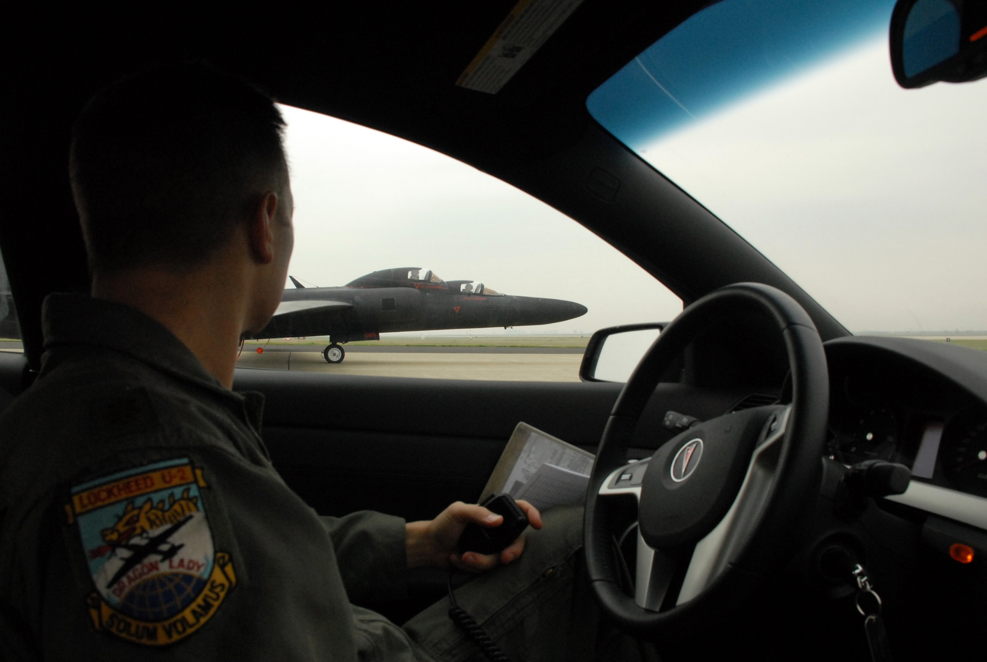Maj. Luke Lokowich with the 1st Reconnaissance Squadron drives around a U-2 Dragon Lady on the runway at Beale Air Force Base, Calif. while keeping inconstant contact with the pilot in the cockpit. The U-2 chase car is the pilots extra eyes and ears on the ground during flight operations. (U.S. Air Force Photo/ Tech. Sgt. Luke Johnson)