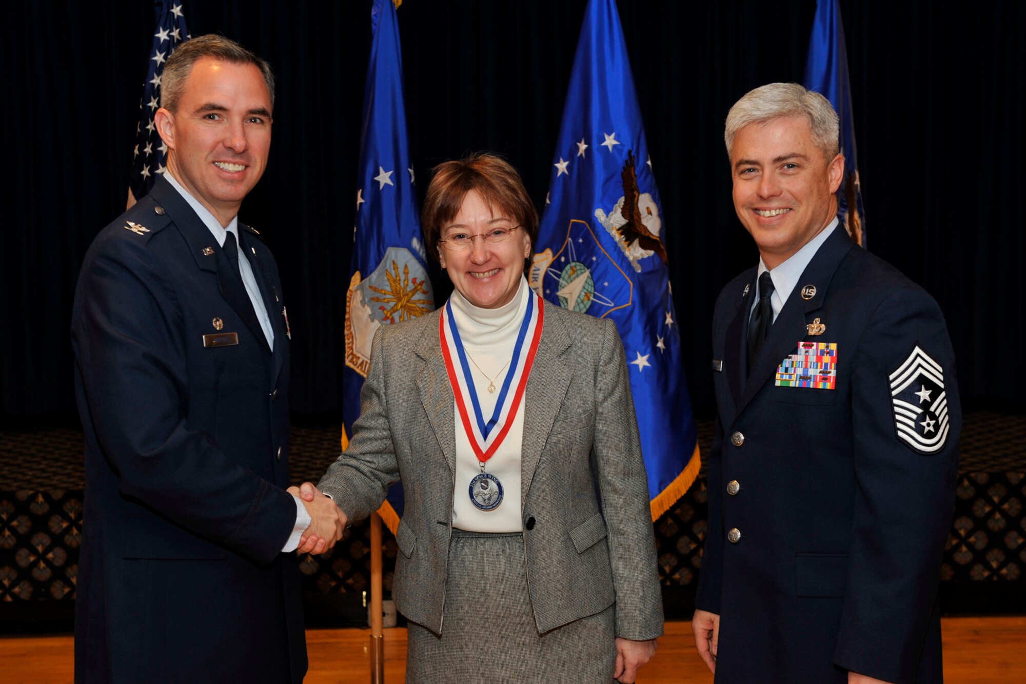 PETERSON AIR FORCE BASE, Colo. -- Col. Stephen N. Whiting (left), 21st SW commander, and Chief Master Sgt. Robert Sealey, 21st SW command chief, present Ms. LJ Van Belkum her annual award nominee medallion Feb. 1 at The Club. Ms. Van Belkum, 21st Space Wing deputy inspector general, was among the nominees for the 21st Space Wing annual awards. The winners will be announced Feb. 5 at the wing’s 2009 annual awards dinner. (Air Force photo by Robb Lingley)