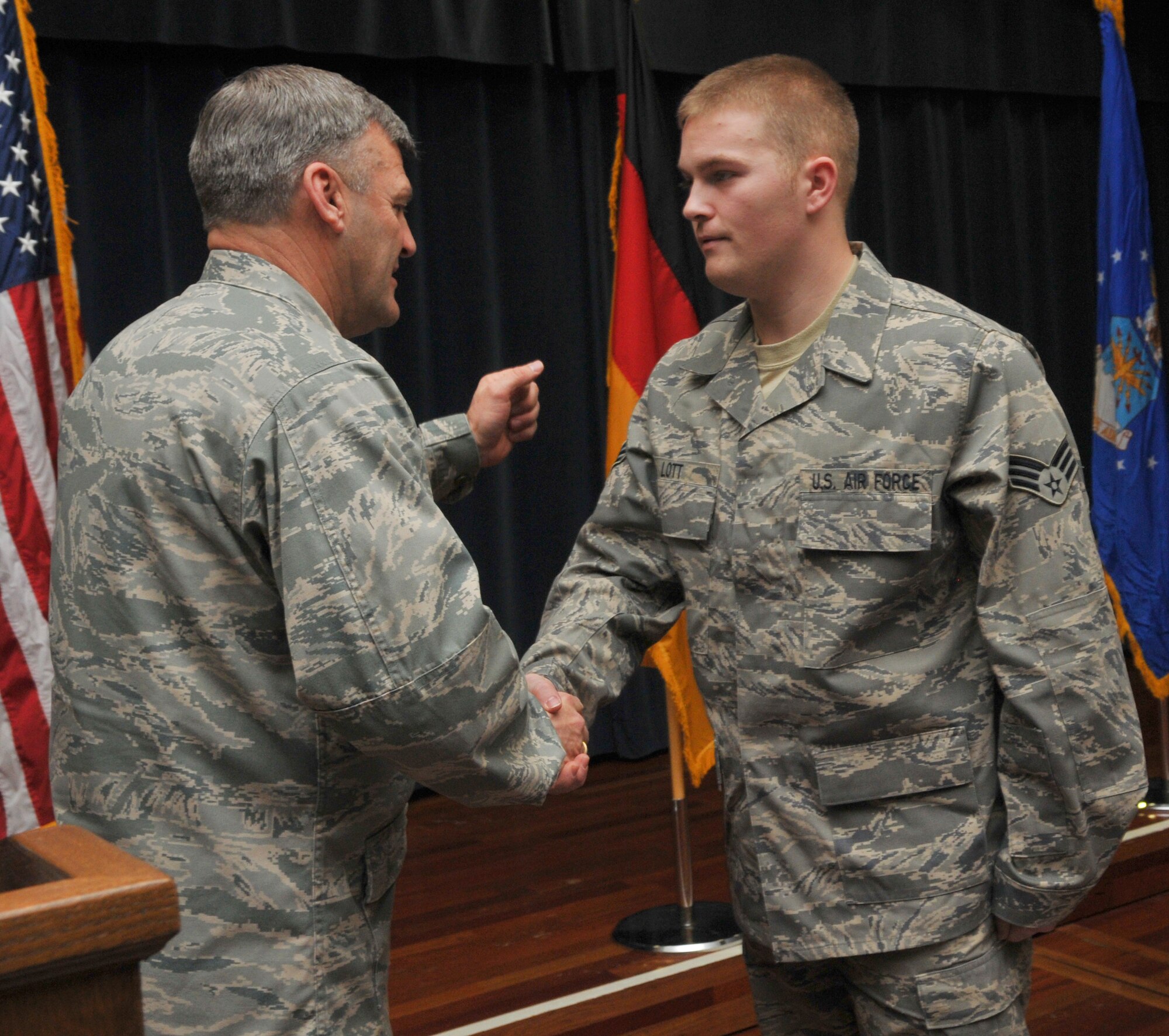 SPANGDAHLEM AIR BASE, Germany -- Chaplain (Brig. Gen.) David Cyr, Air Force deputy chief of chaplains, gives a coin to Senior Airman Patrick Lott, 52nd Communications Squadron, during Spangsahlem's 2010 National Prayer Luncheon Jan. 29 at Club Eifel. Airman Lott was coined as a welcome back from his deployment in Ali Al Saleem Air Base, Kuwait. (U.S. Air Force Photo/Airman 1st Class Nick Wilson)