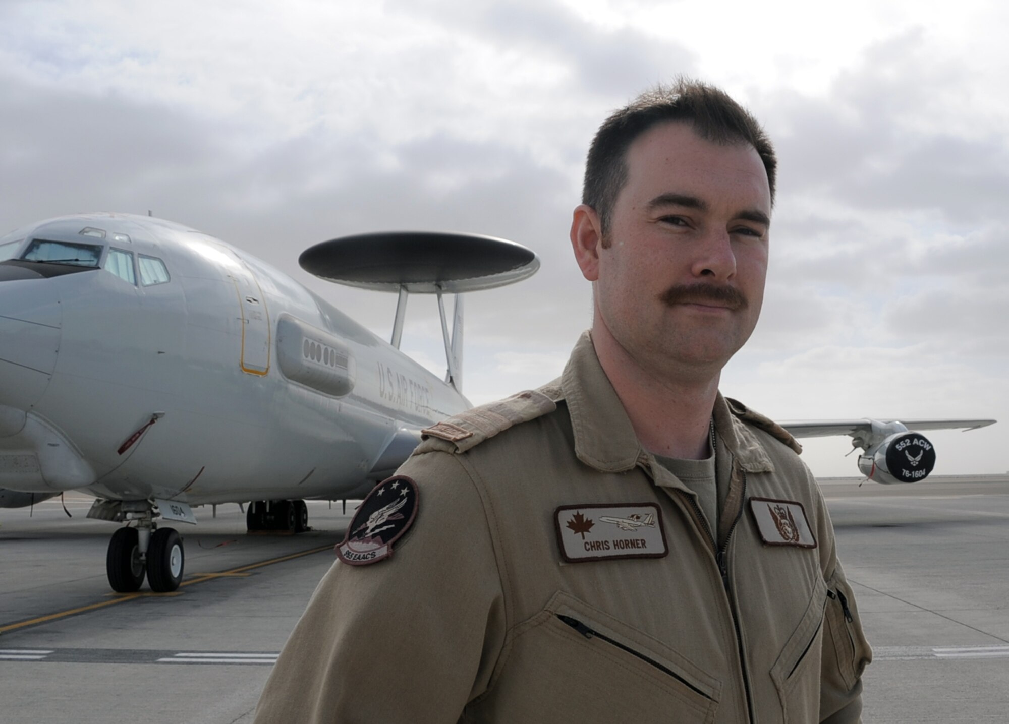 Canadian Forces Capt. Chris Horner stands near an E-3 Sentry Airborne Warning and Control System aircraft at a non-disclosed base in Southwest Asia on Jan. 28, 2010.  Captain Horner is one of five Canadian Forces members deployed with the 965th Expeditionary Airborne Air Control Squadron.  The 11-year Canadian Forces veteran is a Senior Director or a senior weapons officer for the E-3 Sentry.  The captain is deployed from Tinker Air Force Base, Okla., and his hometown is Collingwood, Ontario, Canada.  (U.S. Air Force Photo/Master Sgt. Scott T. Sturkol/Released)