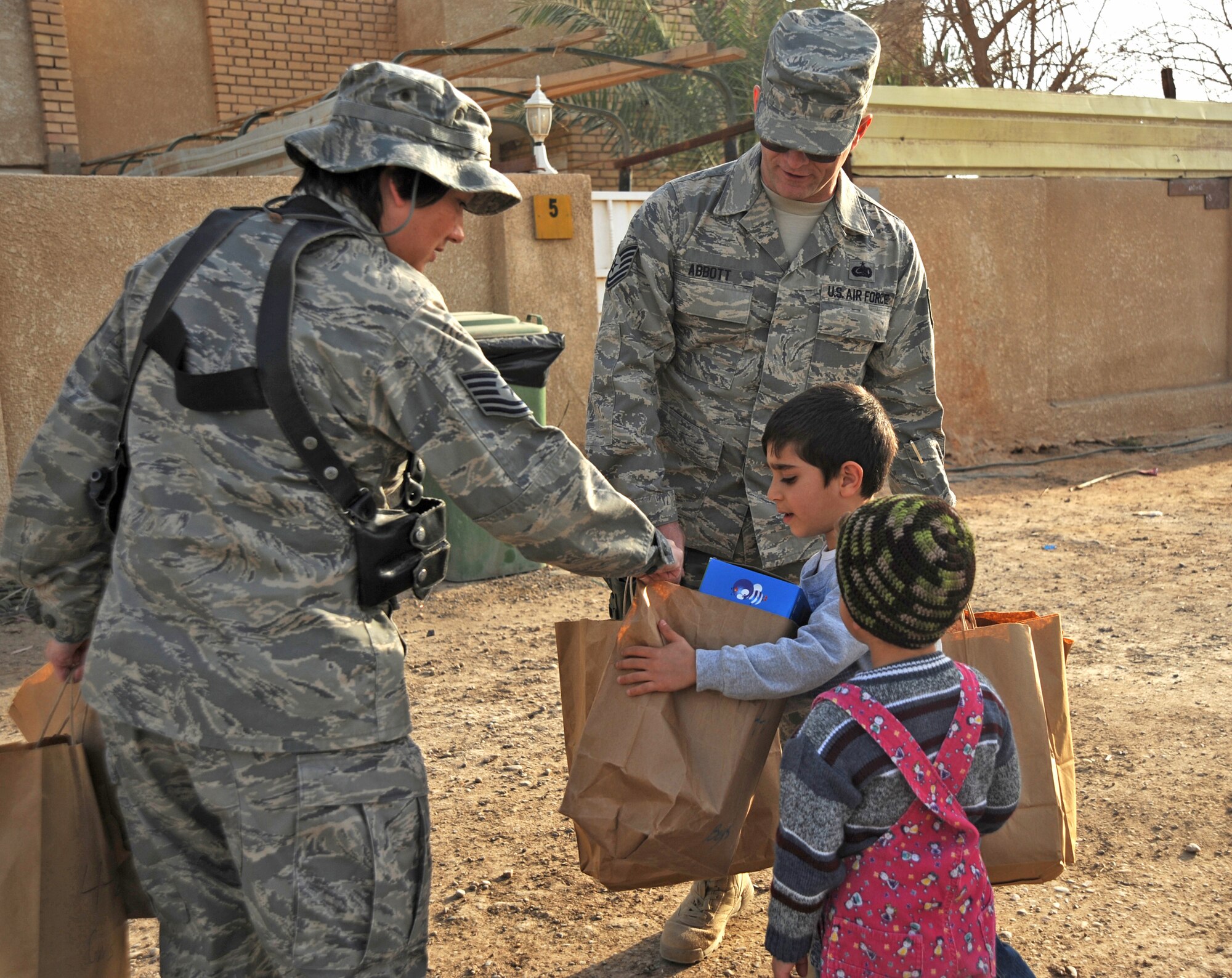 Tech. Sgt. Cynthia Callaway hands a child a bag with toys and games Jan. 29, 2010, near Sather Air Base, Iraq, while volunteering with the Sather AB Rising Six good neighbor program. Sergeant Callaway is assigned to the 447th Expeditionary Logistics Squadron. (U.S. Air Force photo/Senior Airman Eric Summers Jr.)