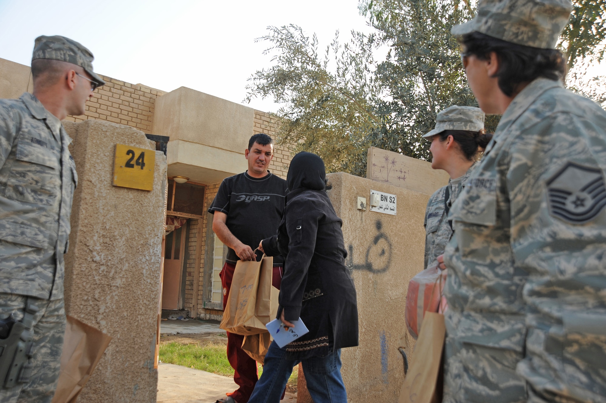 Airmen from Sather Air Base hand out bags of donated goods Jan. 29, 2010, to Iraqis living near Sather Air Base, Iraq, as part of the Sather AB Rising Six good neighbor program. (U.S. Air Force photo/Senior Airman Eric Summers Jr.)