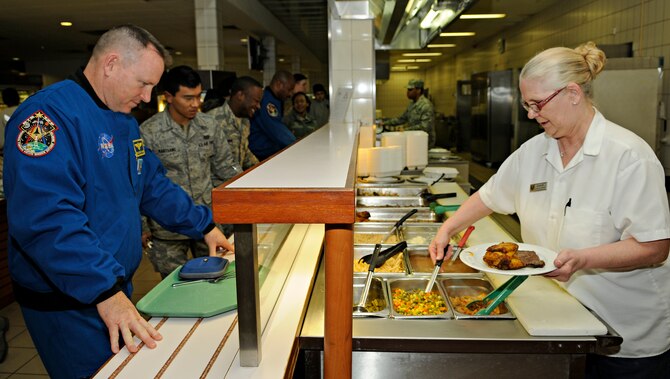 SPANGDAHLEM AIR BASE, Germany – Konne Hill, 52nd Force Support Squadron, serves dinner to Navy Capt. Barry Wilmore, NASA astronaut, at the Mosel Dining Facility Feb. 3. Captain Wilmore was one of six astronauts to visit Spangdahlem Air Base and spoke with students of Spangdahlem’s Airman Leadership School and First Term Airman Center about their recent mission to the international space station before eating dinner with a group of Airmen. (U.S. Air Force photo/Senior Airman Benjamin Wilson)