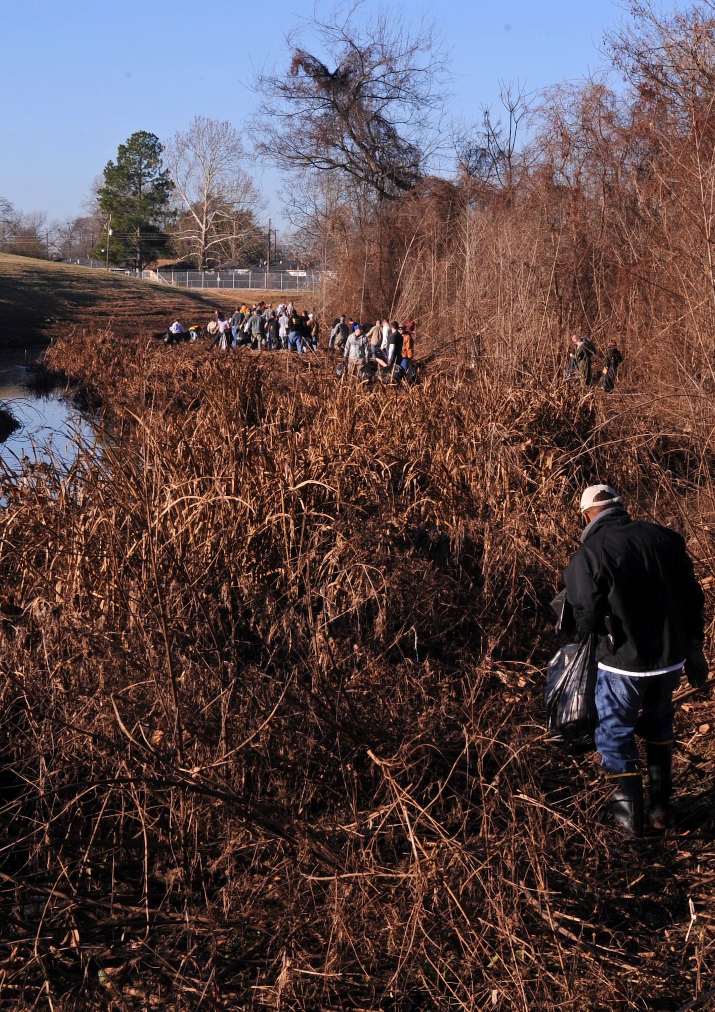 BARKSDALE AIR FORCE BASE, La. – Volunteers pick up trash and other foreign objects along the wet and muddy terrain on Barksdale’s East Reservation. Four hundred volunteers came out to support the east side ditch clean-up project Jan. 22 to help beautify Barksdale. (U.S. Air Force Photo by Senior Airman La’Shanette V. Garrett)(RELEASED)