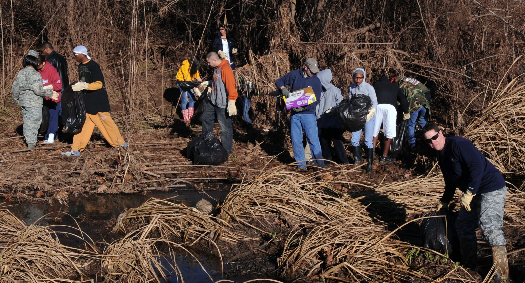 BARKSDALE AIR FORCE BASE, La. – Volunteers pick up trash and other foreign objects along the wet and muddy terrain of the creek bed on Barksdale’s East Reservation. Four hundred volunteers came out to support the east side ditch clean-up project Jan. 22 to help beautify Barksdale. (U.S. Air Force photo by Senior Airman La’Shanette V. Garrett)(RELEASED)