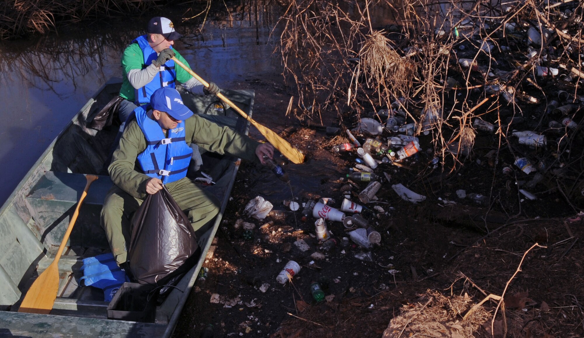 BARKSDALE AIR FORCE BASE, La. – Col. Rob Huber, 2d Mission Support Group commander, and Senior Airman Andre Moulette, 608th Air Operations Center integrated task order technician, row their way to a pile of trash that could not be reached from land on Barksdale’s East Reservation. Four hundred volunteers came out to support the east side ditch clean-up project Jan. 22 to help beautify Barksdale. (U.S. Air Force photo by Senior Airman La’Shanette V. Garrett)(RELEASED)