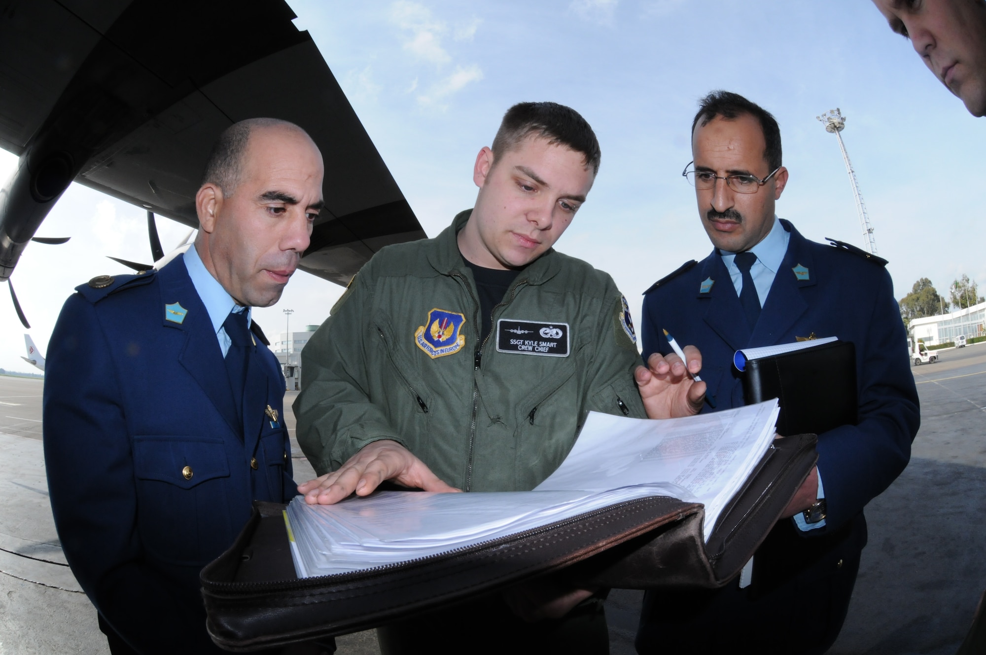 ALGIERS, Algeria -- SSgt. Kyle Smart, 37th Aircraft Maintenance Squadron crew chief, reviews C-130J aircraft forms with Maj. Brouche Ghani and Maj. Yousfi Salah, maintenance officers with the Algerian Air Force, during an engagement visit Jan. 25 in Algiers. (U.S. Air Force photo by Maj. Paula Kurtz)