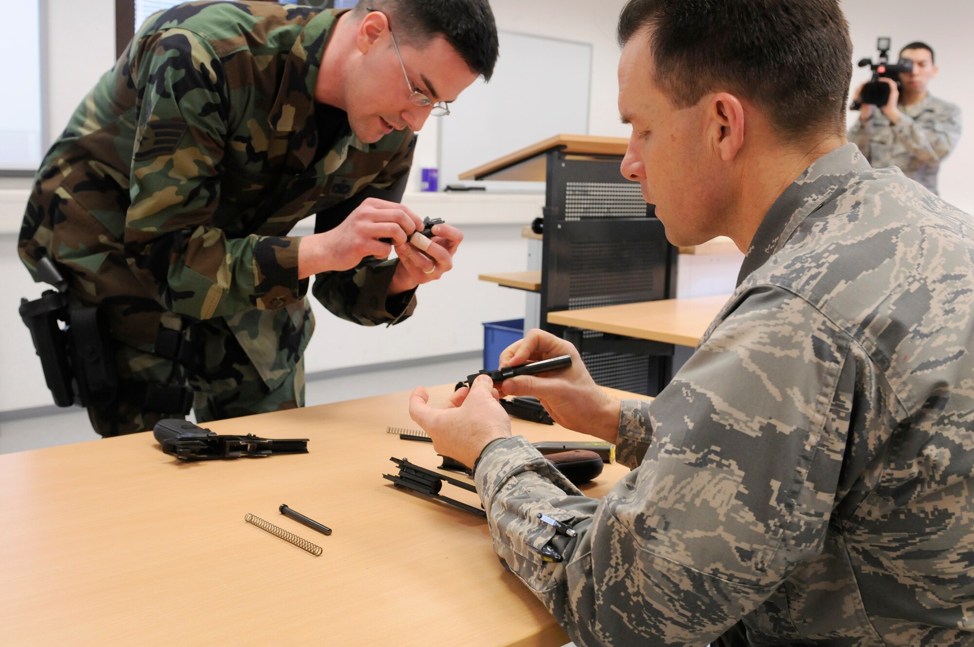 U.S. Air Force Staff Sgt. Nathan Drumm, Combat Arms Training and Maintenance officer, 569th US Forces Police Squadron, instructs Brigadier Gen. Mark Dillon, 86th Airlift Wing commander, with a 9 mm Beretta Pistol on Vogelweh, Germany, Feb. 4, 2010. Combat Arms Training and Maintenance officers train base personnel in the use of small arms weaponry. (U.S. Air Force photo by Airman 1st Class Brea Miller)