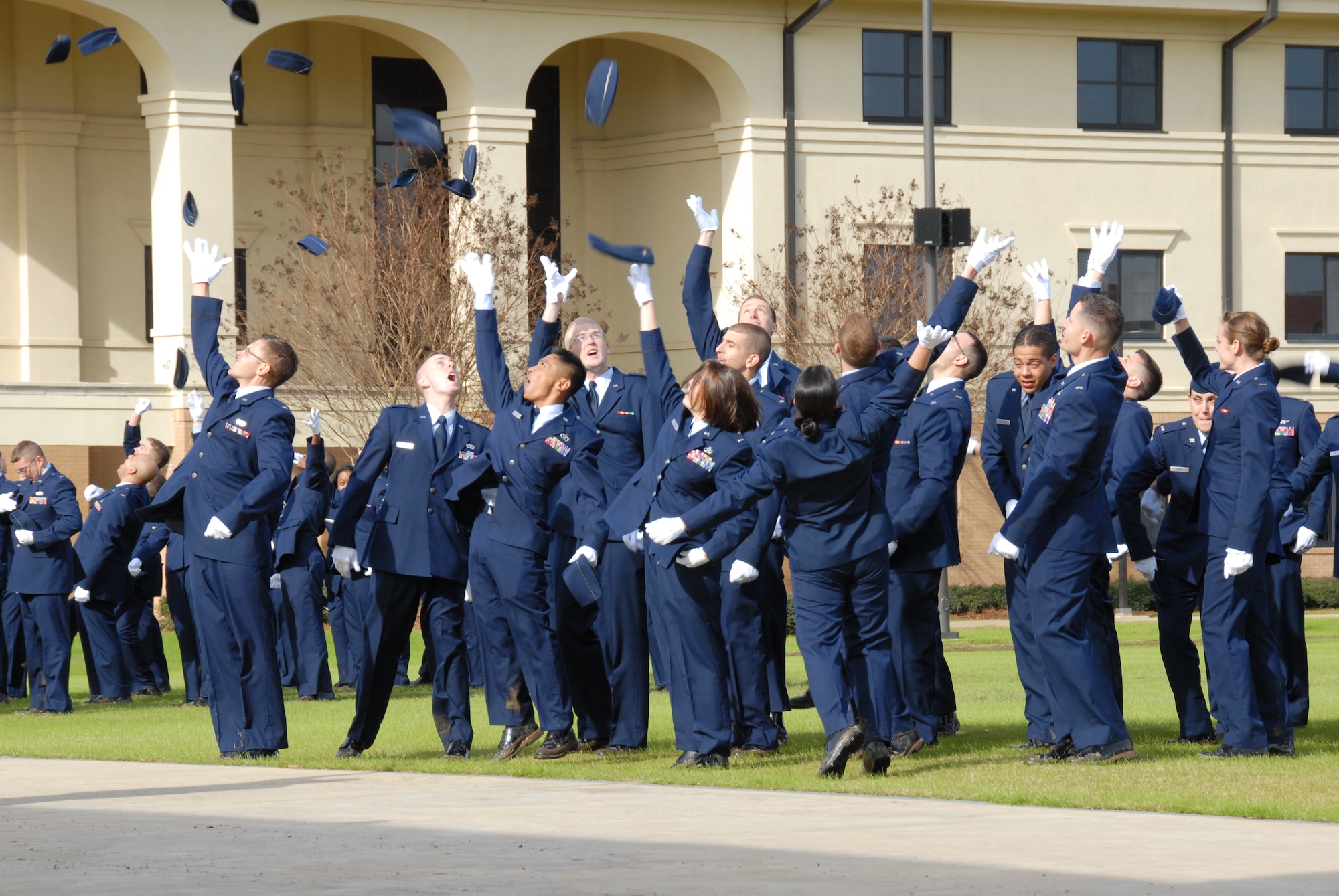 Jubilant graduates from a recent class of the Holm Center Officer Traning School  throw their caps into the air. Today OTS begins a three-day clebration of its 50th anniversary.A retreat ceremony honoring alumni who were killed or missing in action takes place today at 4 p.m and a 5K run takes place Saturday at 7 a.m. The run is open to valid military ID holders and their dependents; a golf tournament follows at 8 a.m. at the Maxwell courses. (Air Force photo by Bennett Rock)