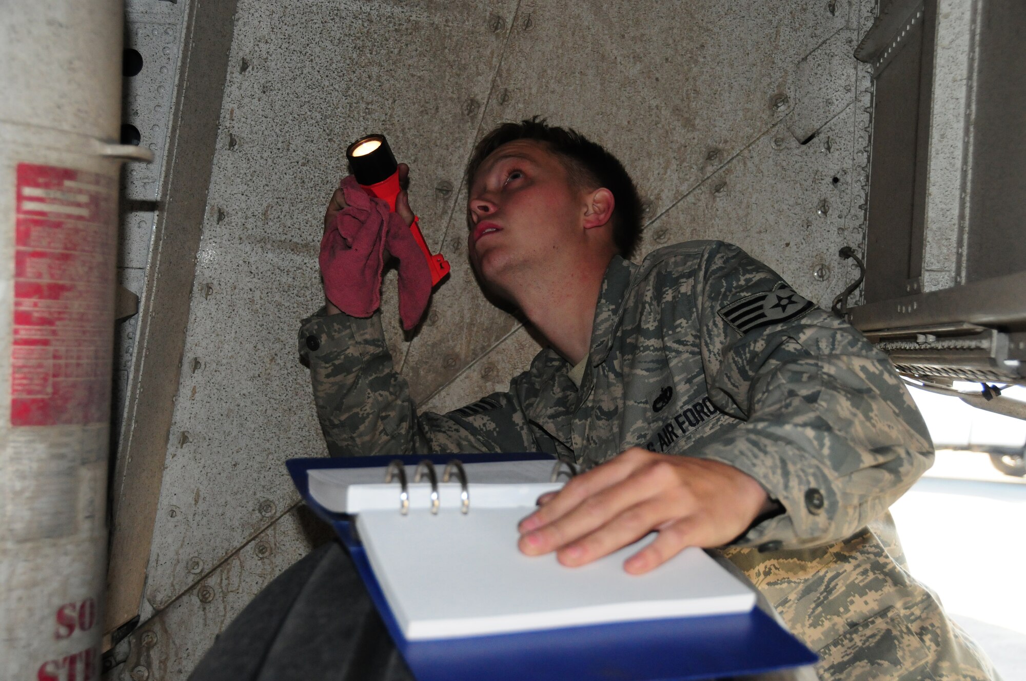U.S. Air Force Staff Sgt. Bradford Lewis, 386th Expeditionary Aircraft Maintenance Squadron C-130H crew chief, inspects the main landing gear wheel well of a C-130 Jan. 22, 2010 at an air base in Southwest Asia. Sergeant Lewis is deployed from Yokota Air Base, Japan. (U.S. Air Force photo by Staff Sgt. Lakisha A. Croley/Released)
