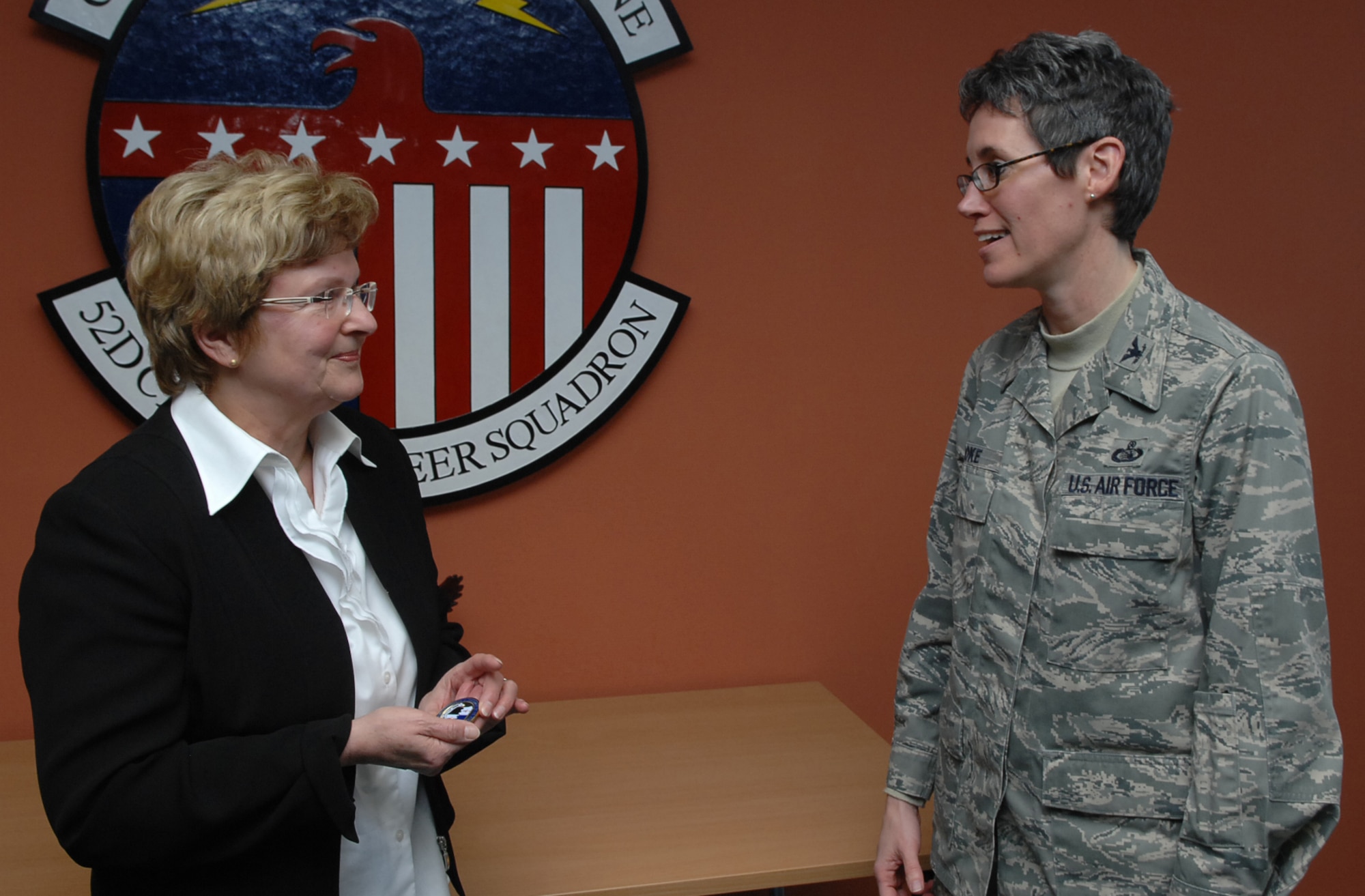 SPANGDAHLEM AIR BASE, Germany -- Col. Jodine Tooke, 52nd Mission Support Group commander, gives a coin to Helga E. Bialluch, retired 52nd Civil Engineer Squadron manpower technician, for her 43 years of dedication and service to Spangdahlem Air Base during her retirement ceremony Jan. 29 in the 52nd CES conference room. Mrs. Bialluch's job was significant to the Air Force and 52nd Fighter Wing because in her position she was responsible for all 52nd CES manpower resources. (U.S. Air Force photo/Airman 1st Class Nick Wilson)
