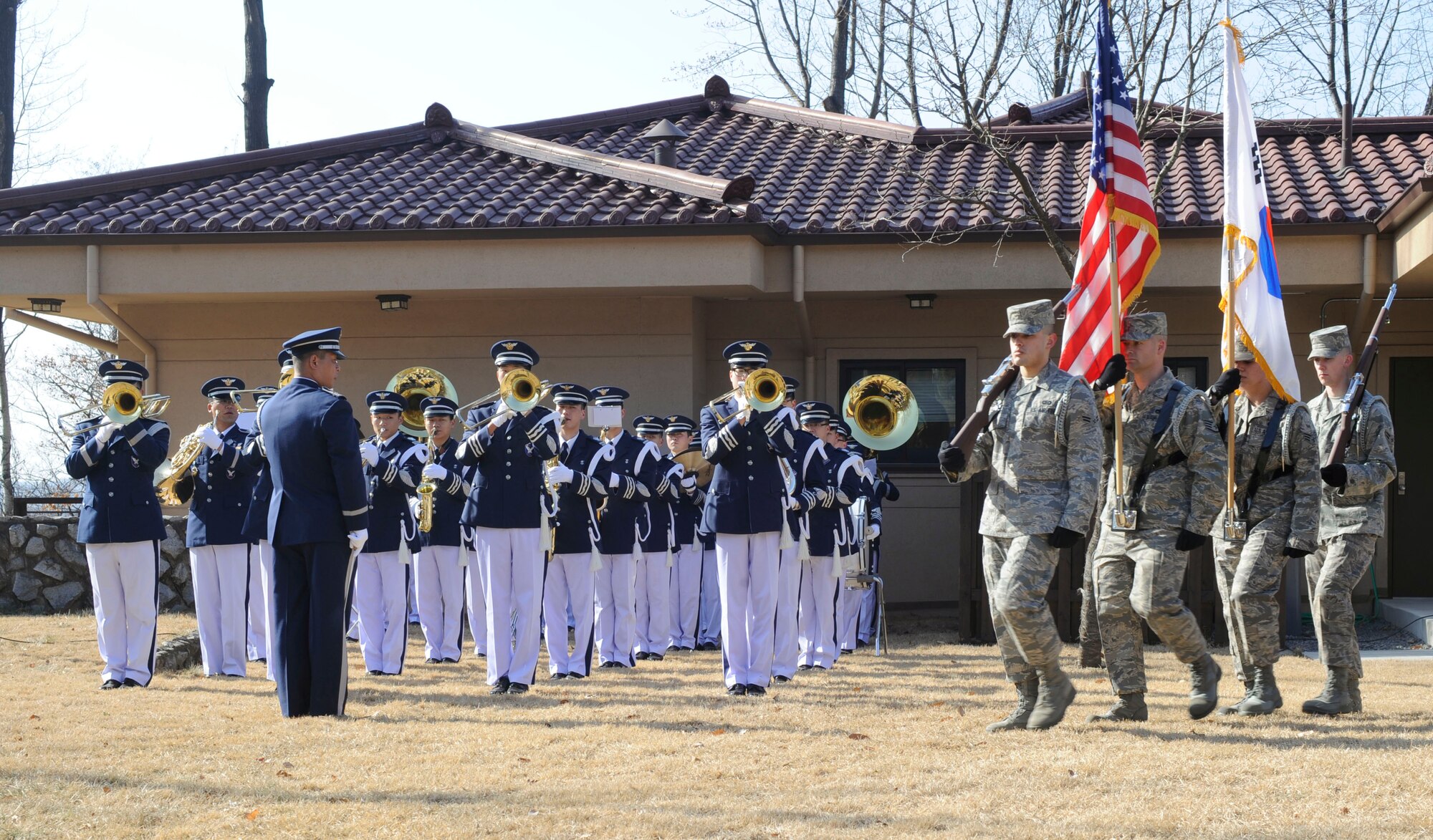 Honor Guard members pass the flag during an annual remembrance ceremony for Hill 180 "Battle of Bayonet Hill" at Osan Air Base, Republic of Korea, Feb. 5.  It was 59 years ago when Col. Lewis Millett lead nine soldiers from the 27th Infantry Division "Wolfhounds" into a bayonet charge up Hill 180 against the enemy where they died from fighting.  A crowd of more than 200 people attended the ceremony. Events included a wreath-placing ceremony, a rifle salute and colors presentation by the Osan Air Base Honor Guard. (U.S. Air Force photo/Senior Airman Stephenie Wade)