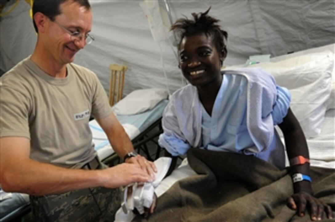 A U.S. Air Force airman attached to the 436th Medical Operations Squadron treats a Haitian woman at an expeditionary medical facility in Port-au-Prince, Haiti, on Feb. 3, 2010.  The Department of Defense and the U.S. Agency for International Development are in Haiti supporting Operation Unified Response, a multinational, joint-service operation to provide humanitarian assistance to Haitians affected by the 7.0-magnitude earthquake that struck the region on Jan. 12, 2010.  