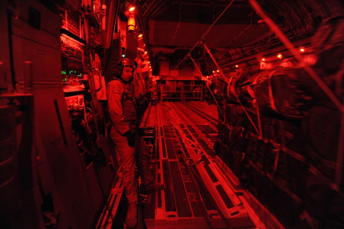 Staff Sgt. Russell C. Johnson, a C-17 Globemaster III loadmaster assigned to the 816th Expeditionary Airlift Squadron, observes forty container-delivery-system bundles of food and water slide off the cargo ramp of a C-17A during a combat airdrop over a forward-operating base in Afghanistan, Feb. 1, 2010.  (U.S. Air Force photo/Staff Sgt. Manuel J. Martinez/released)