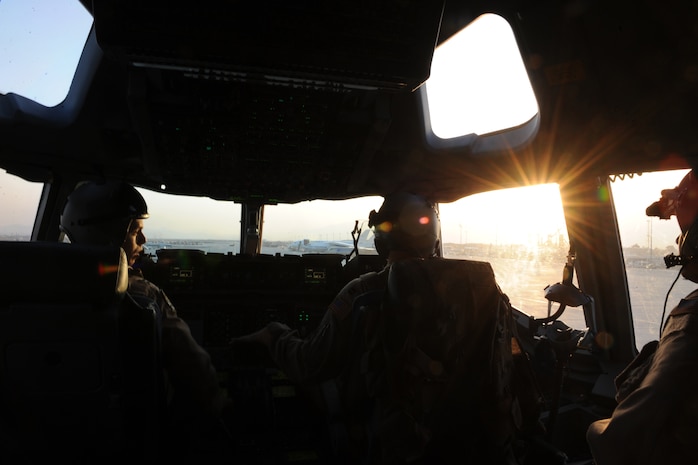 Capt. Brian D. Phillips (left), Capt. Marcus F. Youngquist and Capt. Gabriel Chavarria, all  C-17 Globemaster III pilots assigned to the 816th Expeditionary Airlift Squadron, park a C-17 at Bagram Air Base, Afghanistan, Feb. 1, 2010. The C-17 is equipped with two heads-up displays allowing pilots to fly their planned approach with their heads up, looking out of the cockpit by superimposing the necessary cues on their outside field of view.  (U.S. Air Force photo/Staff Sgt. Manuel J. Martinez/released)