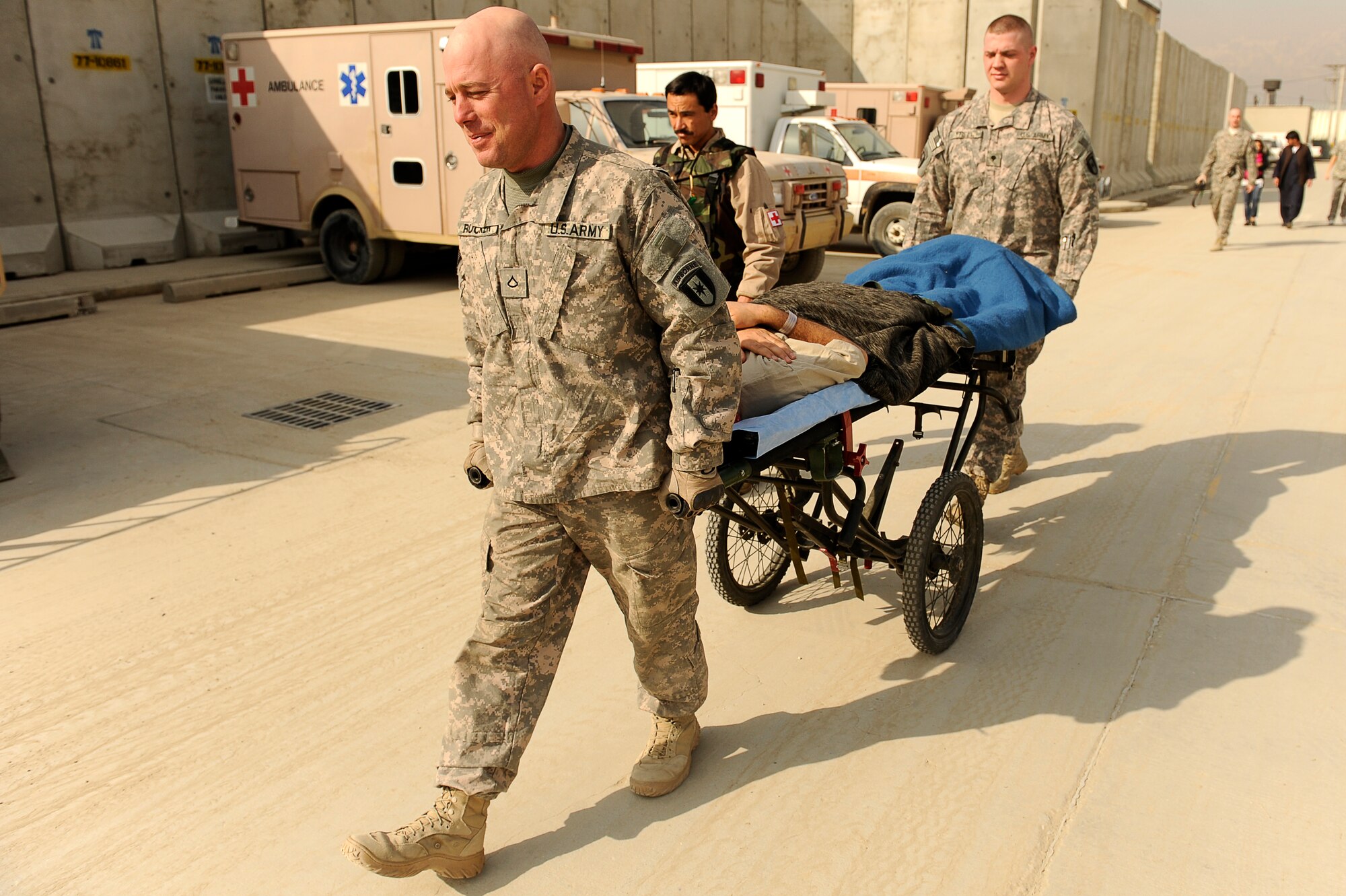 BAGRAM AIRFIELD, Afghanistan--U.S. Army Pfc. Jeff Rucker (front), Spc. Nathan Freel (rear), 36th Air Support Medical Company, and Afghan Sgt. 1st Class Ghulam Sakhi, flight medic with the 438th Air Expeditionary Advisory Group/Combined Air Power Task Force, escort an Afghan solder to a rotary wing medical evacuation on Bagram Airfield Feb. 3, 2010. This rotary wing medevac is the first of its kind in Afghanistan, where a combined Afghan and U.S. crew takes Afghans from coalition medical facilities and returns them to Afghan facilities. (U.S. Air Force photo by/ Tech. Sgt. Jeromy K. Cross/released)