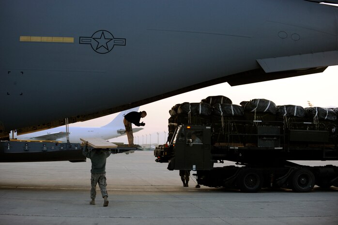 Staff Sgt. Chris Rapp, a C-17 Globemaster III loadmaster assigned to the 816th Expeditionary Airlift Squadron, guides a cargo-loader driver toward the aircraft's ramp Feb. 1, 2010, at Bagram Air Base, Afghanistan. Airmen and Soldiers loaded forty pallets of food and water to be air-dropped to U.S. and Coalition forces in remote areas of Afghanistan. (U.S. Air Force photo/Staff Sgt. Manuel J. Martinez/released)