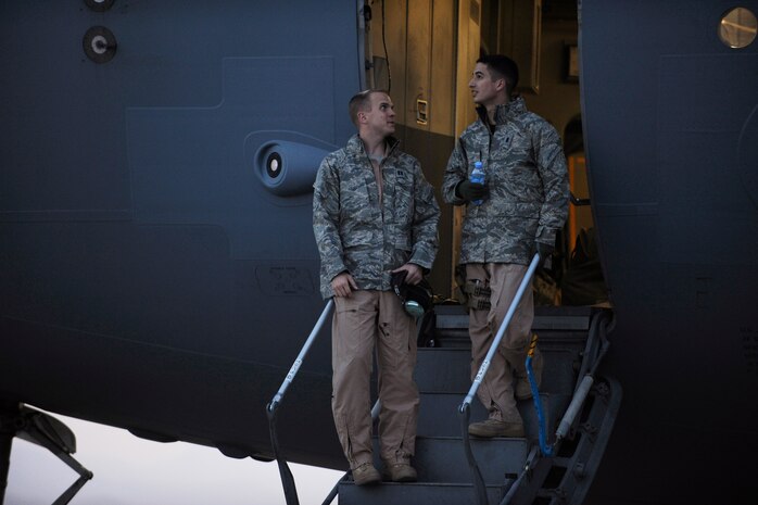 Capt. Marcus F. Youngquist (left) and 1st Lt. Kyle J. Stewart, both C-17 Globemaster III pilots assigned to the 816th Expeditionary Airlift Squadron, step out of their aircraft to discuss the day's flight plan, while Soldiers and Airmen load 60,000 pounds of supplies into the aircraft Feb. 1, 2010, at Bagram Air Base, Afghanistan.  (U.S. Air Force photo/Staff Sgt. Manuel J. Martinez/released)