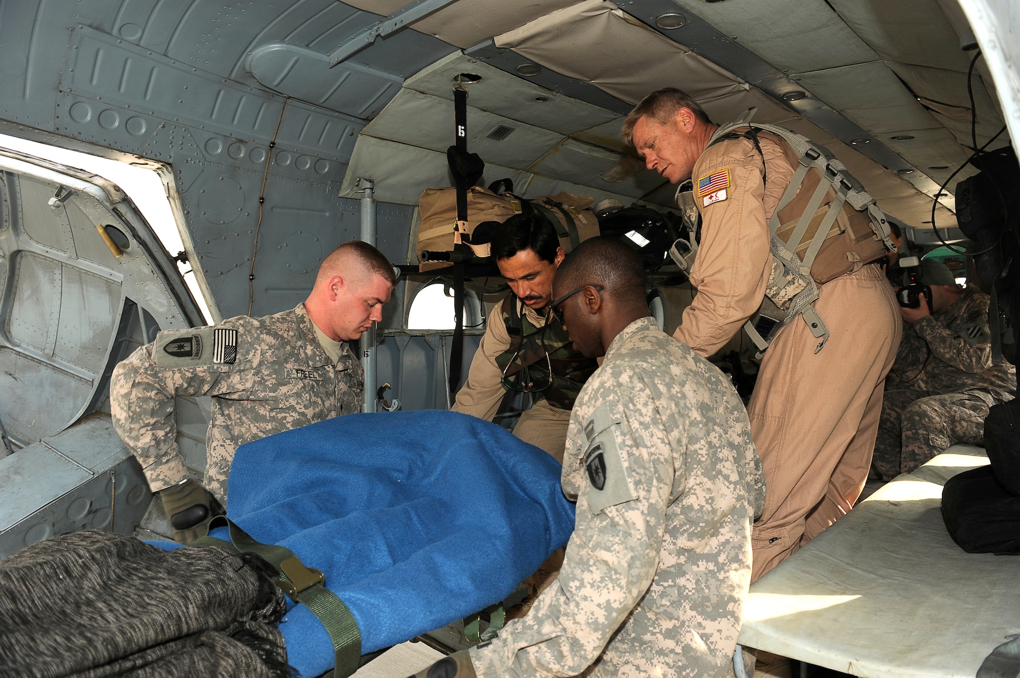 BAGRAM AIRFIELD, Afghanistan--U.S. Army Spc. Nathan Freel (left), and Spc. Ed Okul, 36th Air Support Medical Company, help Afghan Sgt. 1st Class Ghulam Sakhi, and U.S. Air Force Master Sgt. Richard Kramer, flight medics with the 438th Air Expeditionary Advisory Group/Combined Air Power Task Force, load an Afghan solder into an Mi-17 for a rotary wing medical evacuation on Bagram Airfield Feb. Feb. 3, 2010. This rotary wing medevac is the first of its kind in Afghanistan, where a combined Afghan and U.S. crew takes Afghans from coalition medical facilities and returns them to Afghan facilities. (U.S. Air Force photo by/ Tech. Sgt. Jeromy K. Cross/released)