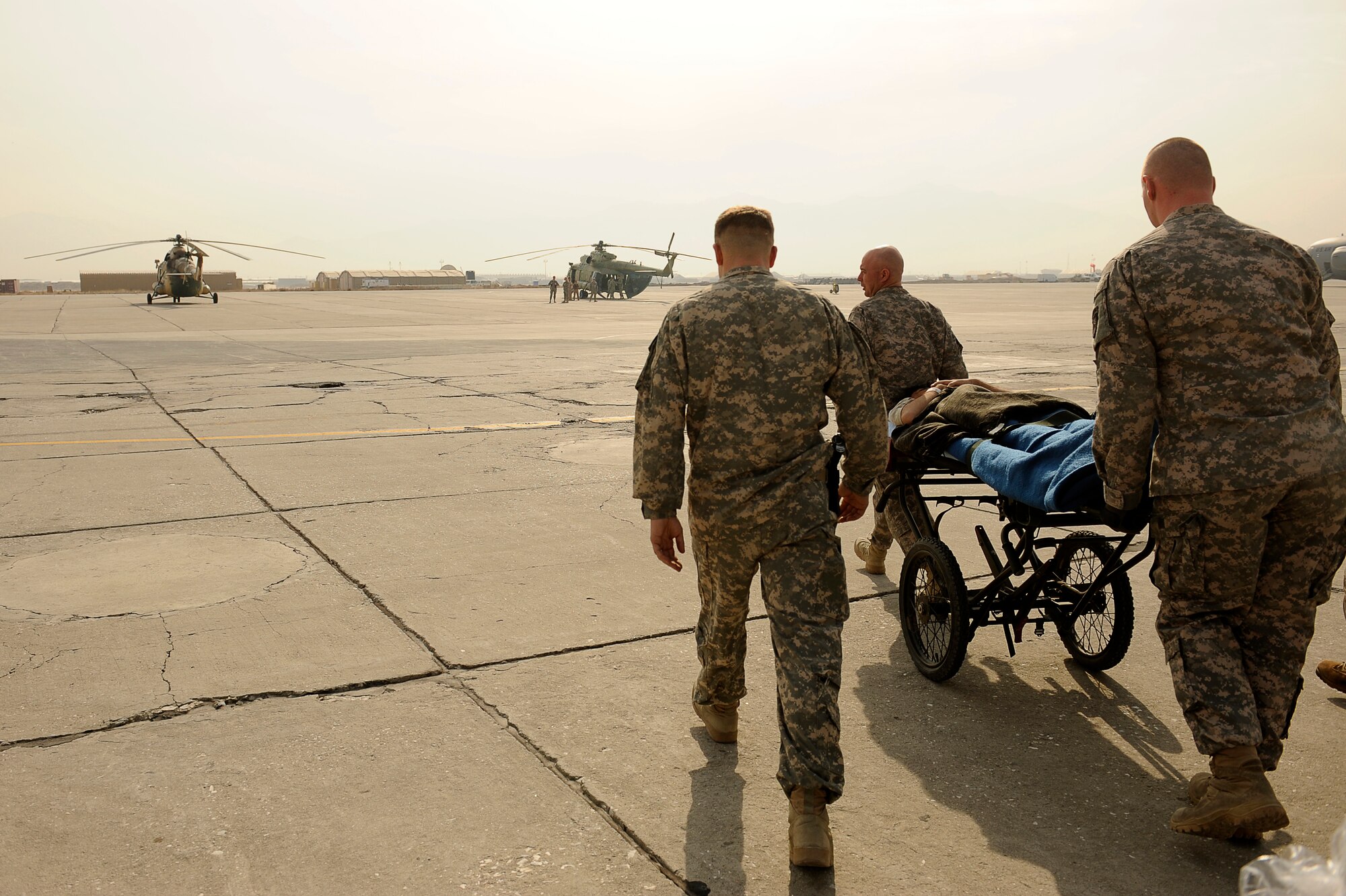 BAGRAM AIRFIELD, Afghanistan--U.S. Army Staff Sgt. David Marshall (left), Charley Company, 2-3 Aviation, Task Force Knighthawk, Pfc. Jeff Rucker (lead), and Spc. Nathan Freel, 36th Air Support Medical Company, escort an Afghan solder to a rotary wing medical evacuation on Bagram Airfield Feb. 3, 2010. This rotary wing medevac is the first of its kind in Afghanistan, where a combined Afghan and U.S. crew takes Afghans from coalition medical facilities and returns them to Afghan facilities. (U.S. Air Force photo by/ Tech. Sgt. Jeromy K. Cross/released)