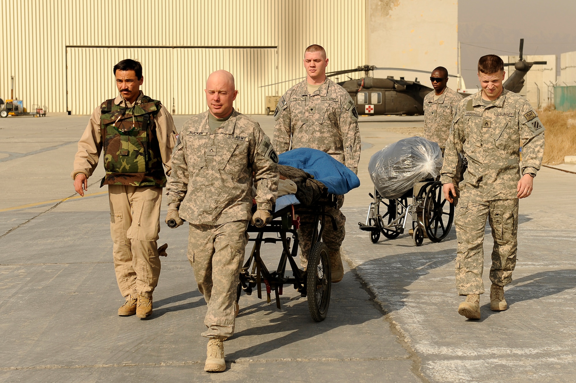 BAGRAM AIRFIELD, Afghanistan--U.S. Army soldiers from the 36th Air Support Medical Company, and Afghan Sgt. 1st Class Ghulam Sakhi (left), flight medic with the 438th Air Expeditionary Advisory Group/Combined Air Power Task Force, escort an Afghan solder to a rotary wing medical evacuation on Bagram Airfield Feb. 3, 2010. This rotary wing medevac is the first of its kind in Afghanistan, where a combined Afghan and U.S. crew takes Afghans from coalition medical facilities and returns them to Afghan facilities. (U.S. Air Force photo by/ Tech. Sgt. Jeromy K. Cross/released)