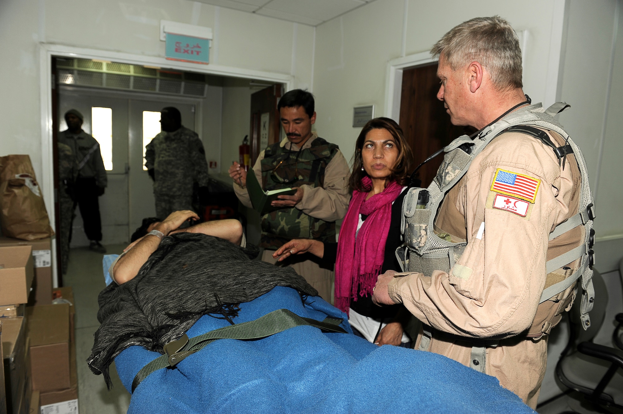 BAGRAM AIRFIELD, Afghanistan--U.S. Air Force Master Sgt. Richard Kramer and Afghan Sgt. 1st Class Ghulam Sakhi, flight medics with the 438th Air Expeditionary Advisory Group/Combined Air Power Task Force, discuss with an Afghan soldier through Shakira Azzizi, an Afghan translator, what is going to happen on a rotary wing medical evacuation from Bagram Airfield Feb. 3, 2010. This rotary wing medevac is the first of its kind in Afghanistan, where a combined Afghan and U.S. crew takes Afghans from coalition medical facilities and returns them to Afghan facilities. (U.S. Air Force photo by/ Tech. Sgt. Jeromy K. Cross/released)