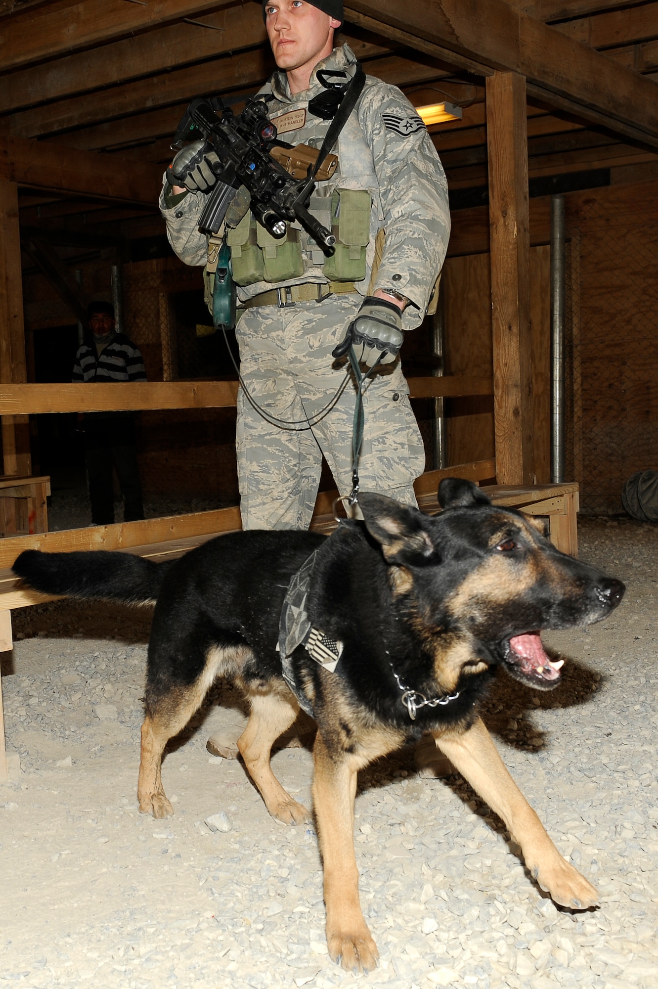 BAGRAM AIRFIELD, Afghanistan--U.S. Air Force Staff Sgt. Mitchell Stein and Artus, a military working dog, 455th Expeditionary Security Forces Squadron act as crowd control at an entry control point on Bagram Airfield, Feb. 2, 2010. Sgt. Stein is from Crescent City, Ill., he and Artus are deployed from Spangdahlem Air Base, Germany. (U.S. Air Force photo by/ Tech. Sgt. Jeromy K. Cross/released)