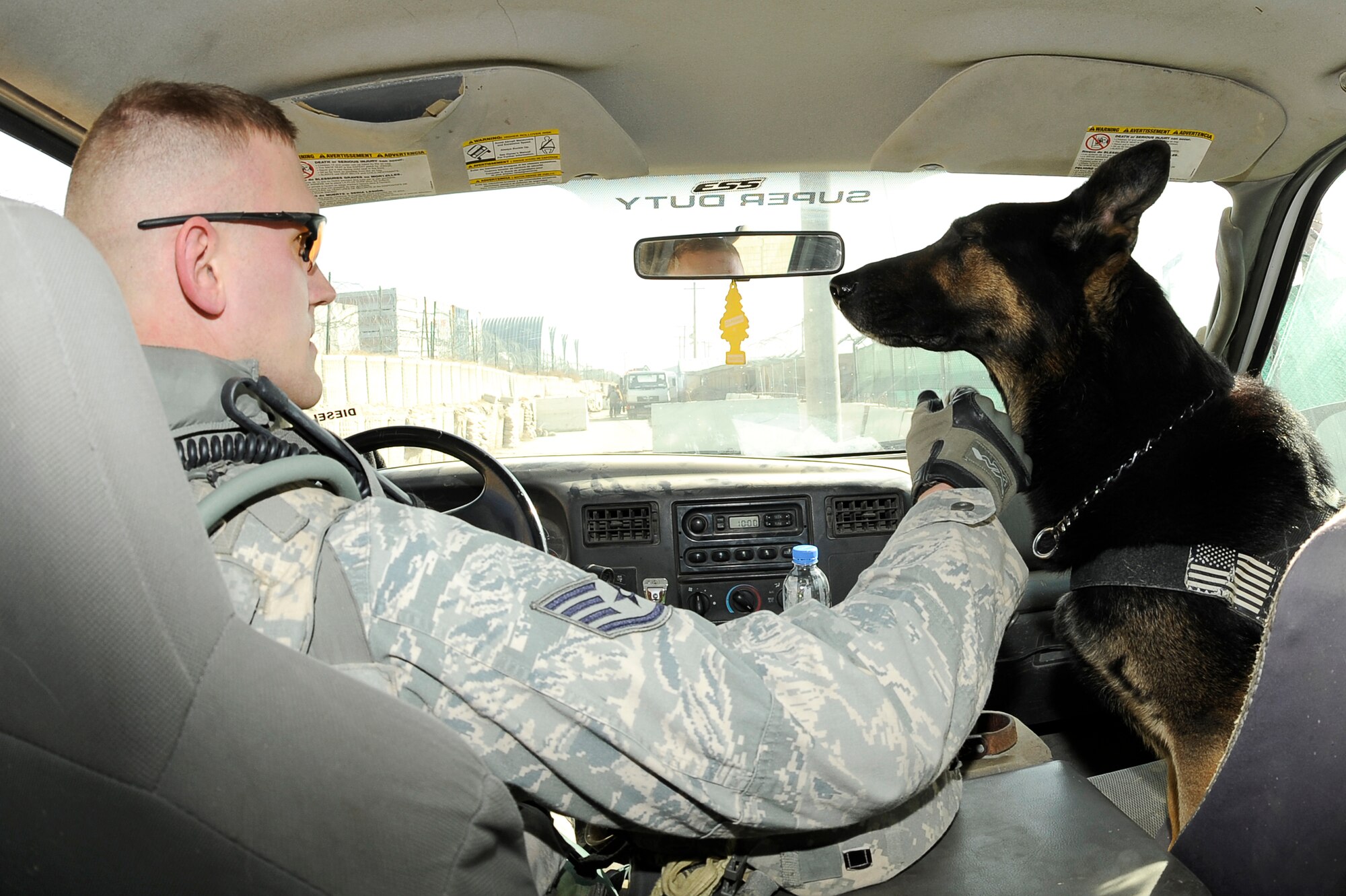 BAGRAM AIRFIELD, Afghanistan--U.S. Air Force Staff Sgt. Mitchell Stein and Artus, a military working dog, 455th Expeditionary Security Forces Squadron drive back from an entry control point on Bagram Airfield, Feb. 2, 2010. Sgt. Stein is from Crescent City, Ill., he and Artus are deployed from Spangdahlem Air Base, Germany. (U.S. Air Force photo by/ Tech. Sgt. Jeromy K. Cross/released)
