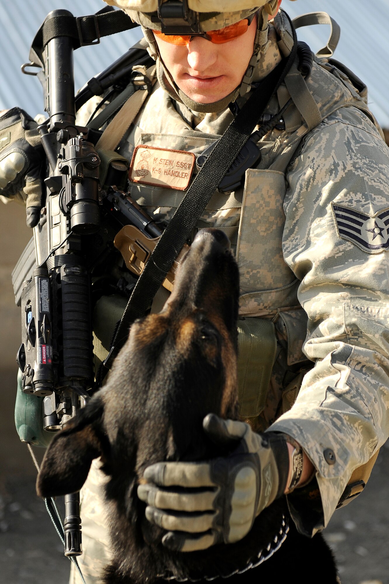 BAGRAM AIRFIELD, Afghanistan--U.S. Air Force Staff Sgt. Mitchell Stein and Artus, a military working dog, 455th Expeditionary Security Forces Squadron take a break from their patrol on Bagram Airfield, Feb. 2, 2010. Sgt. Stein is from Crescent City, Ill., he and Artus are deployed from Spangdahlem Air Base, Germany. (U.S. Air Force photo by/ Tech. Sgt. Jeromy K. Cross/released)