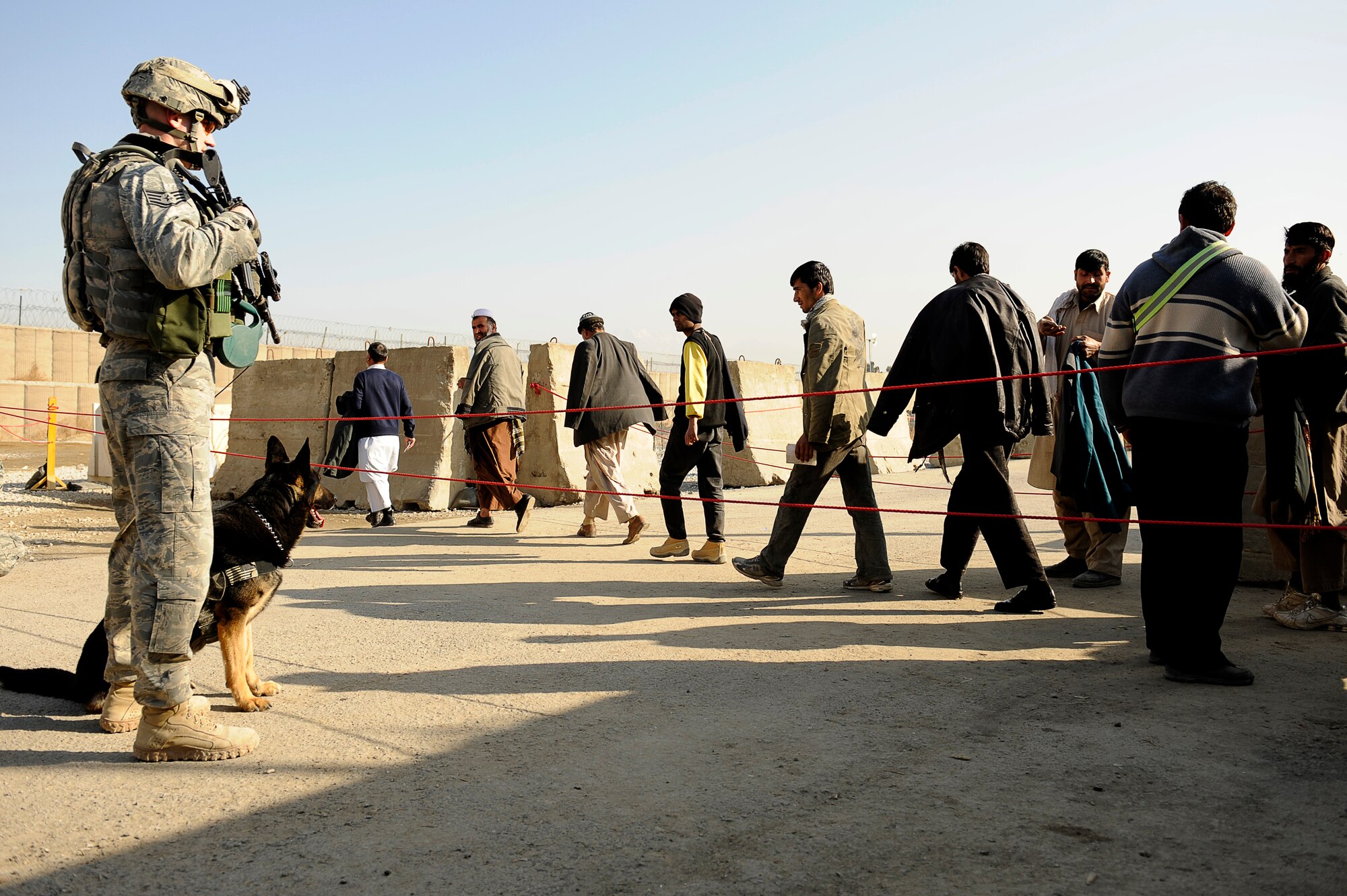 BAGRAM AIRFIELD, Afghanistan--U.S. Air Force Staff Sgt. Mitchell Stein and Artus, a military working dog, 455th Expeditionary Security Forces Squadron watch Afghans enter Bagram Airfield, Feb. 2, 2010. Sgt. Stein is from Crescent City, Ill., he and Artus are deployed from Spangdahlem Air Base, Germany. (U.S. Air Force photo by/ Tech. Sgt. Jeromy K. Cross/released)