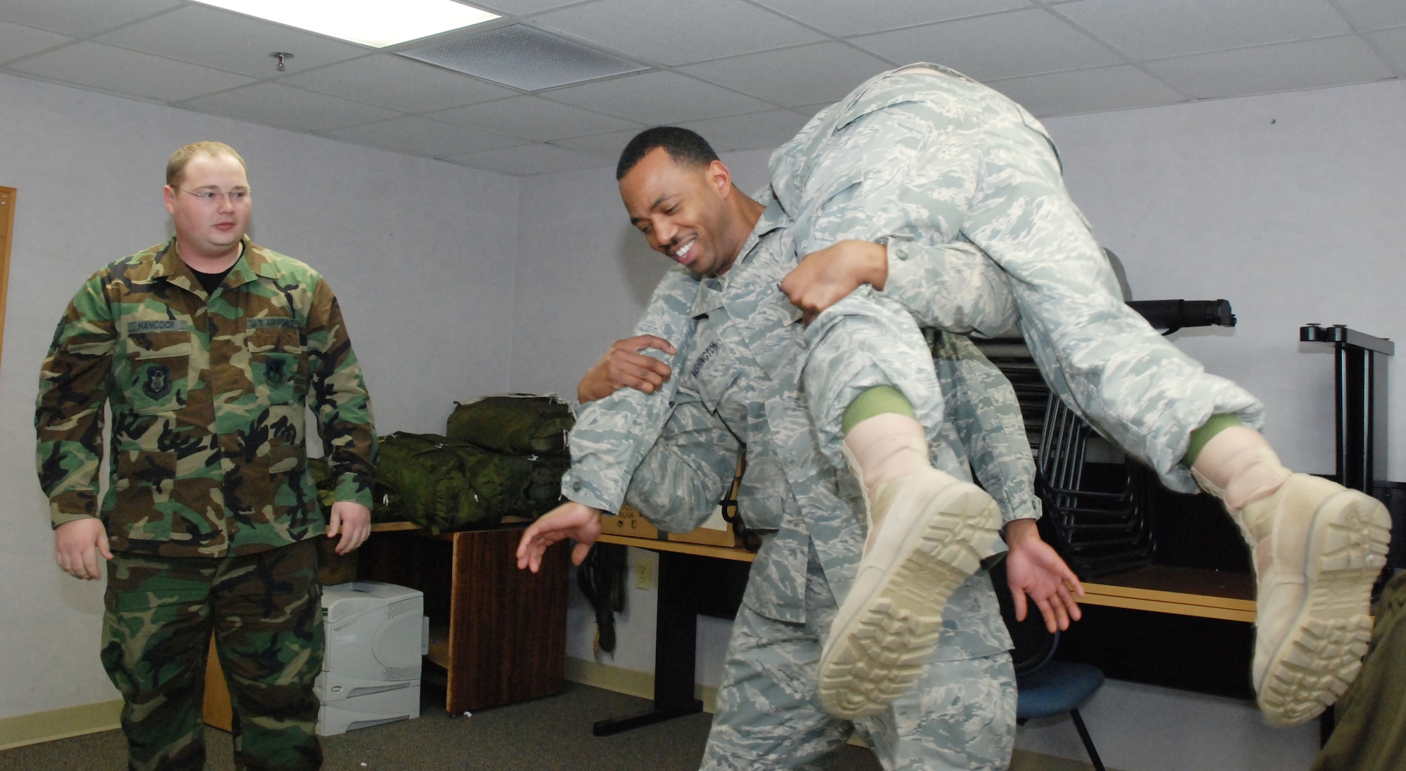 Staff Sgt. Rocky Hancock, 80th Aerial Port Squadron Self-Aid Buddy Care instructor (left), instructs Staff Sgt. Rodriquez Washington, 94th Airlift Wing chaplain's assistant, on the correct technique of executing a one-man transport technique called the Fireman's Carry.  

Self Aid Buddy Care is the Air Force instruction on preparing Airmen for injuries on the battlefield and other possible accident scenarios.  (U.S. Air Force photo/Master Sgt./ Stan Coleman)
