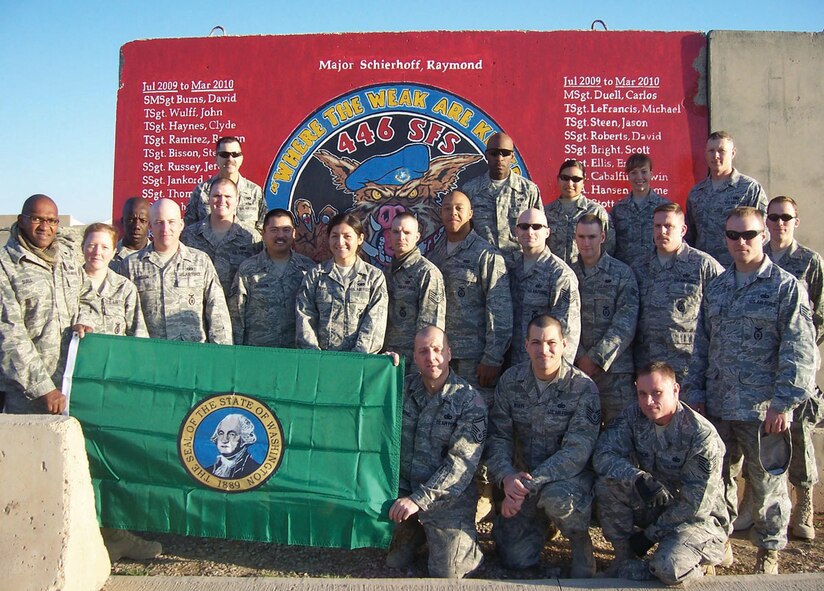 KIRKUK AIR BASE, Iraq -- Reservists from the 446th Security Forces Squadron, Joint Base Lewis-McChord, McChord Field, Wash., stand in front of a mural here before returning home from a recent six-month deployment in support of Operation Iraqi Freedom. With a little help from his friends, Tech Sgt. John Wulff, 446th SFS, created the mural to honor the dedication of the 23 squadron members who were part of this deployment. It was the largest group of 446th SFS Reservists deployed at one time. (U.S. Air Force photo/Senior Master Sgt. David Burns)
