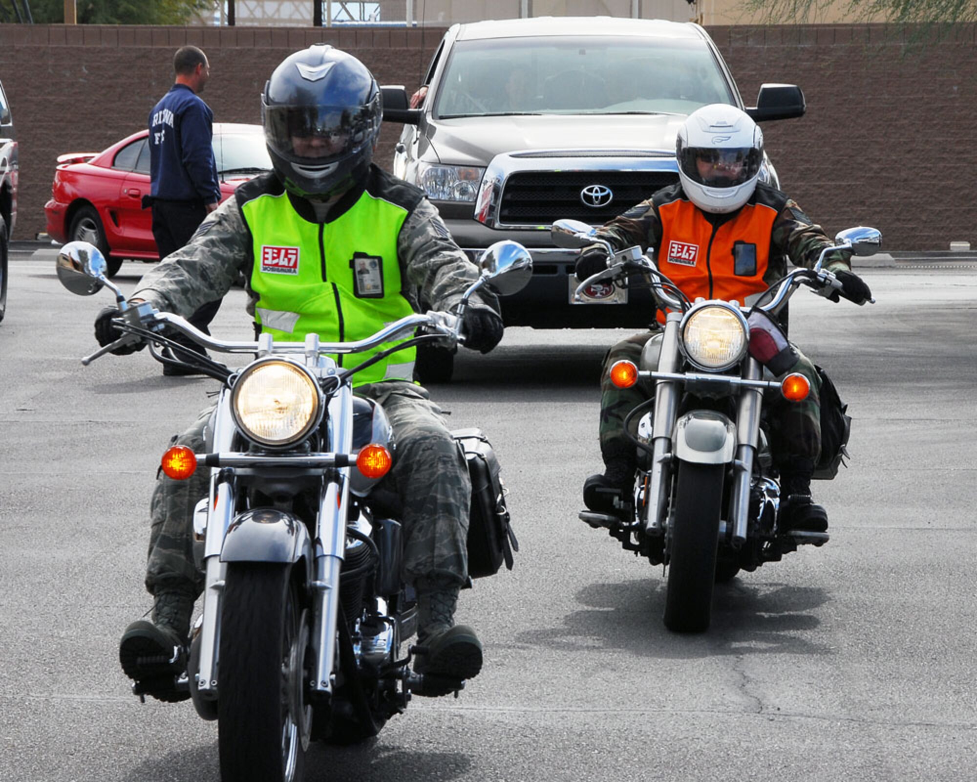 Staff Sgt. Mike Bailey, left, and Tech. Sgt. Fabian Cosper ride motorcycles on base while wearing newly issued reflective vests, Feb. 5. The 162nd Fighter Wing Safety Office will hand out 150 vests to assigned Airmen who ride. They were purchased under Air Force Instruction 91-202, the Air Force Mishap Prevention Program, which states unit funds may be used to prevent mishaps. (Air Force photo by Master Sgt. Dave Neve)