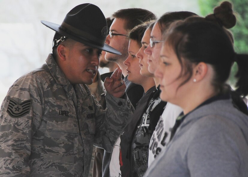 Tech. Sgt. Raul Lopez, 96th Logistics Readiness Squadron, corrects a new Air Force Reserve recruit Feb. 6 at Duke Field.  Sergeant Lopez and his wife, Master. Sgt. Tiffany Lopez (pictured), 96th Force Support Squadron, both former active-duty military training instructors at Lackland AFB, Texas, volunteered their time to help new reserve recruits prepare for basic training during the drill weekend here.  The husband and wife team spent four years instructing new trainees at Lackland graduating 25 flights from Basic Military Training.  (U.S. Air Force photo/Tech. Sgt. Samuel King Jr.) 