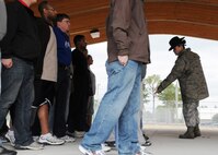 Master Sgt. Tiffany Lopez, 96th Force Support Squadron, directs a recruit to adjust their feet while practicing facing movements Feb. 6 at Duke Field.  Sergeant Lopez and her husband, Tech. Sgt. Raul Lopez, 96th Logistics Readiness Squadron, both former active-duty military training instructors at Lackland AFB, Texas, volunteered their time to help new reserve recruits prepare for basic training during the drill weekend here.  The husband and wife team spent four years instructing new trainees at Lackland, graduating 25 flights from Basic Military Training.  (U.S. Air Force photo/Tech. Sgt. Samuel King Jr.)